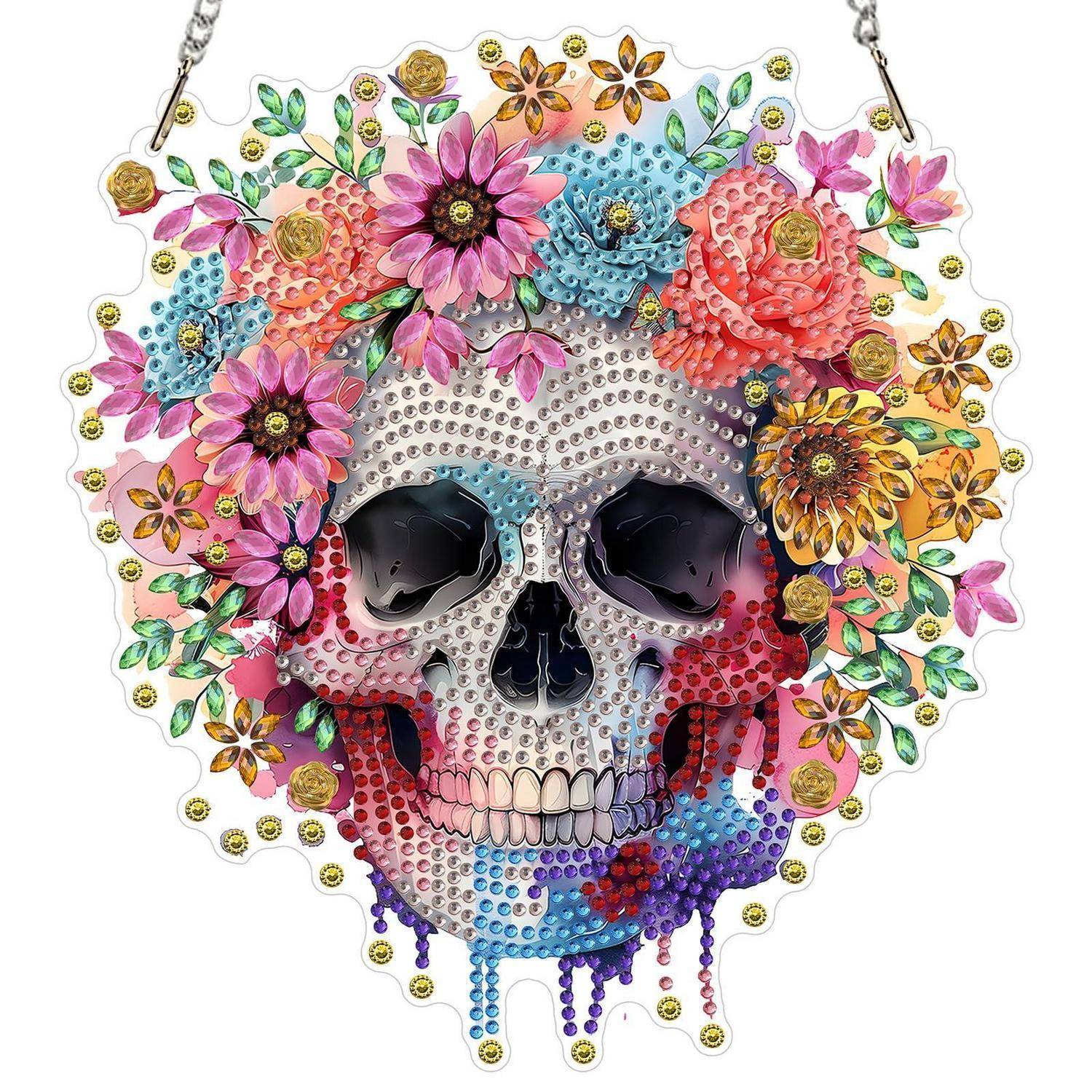 Dekorativer Totenkopfanhänger oder Kunstwerk mit Schmucksteinen, bedeckt mit bunten Blüten und Perlen auf weißem Hintergrund.