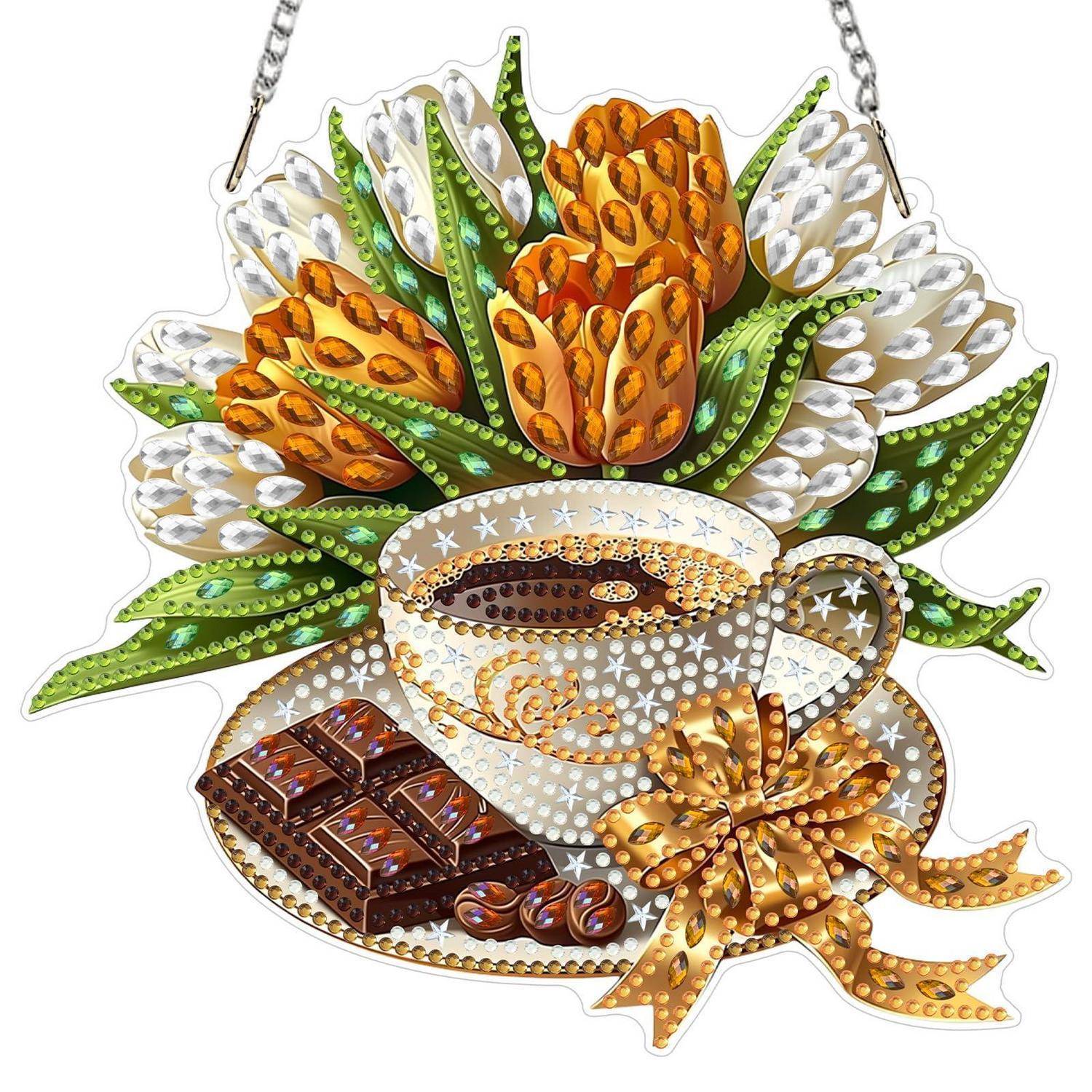 Dekoratives Hängeornament einer Kaffeetasse und Untertasse mit Schokoladenstücken, goldener Schleife und Tulpenstrauß in Grün, Weiß und Orange.
