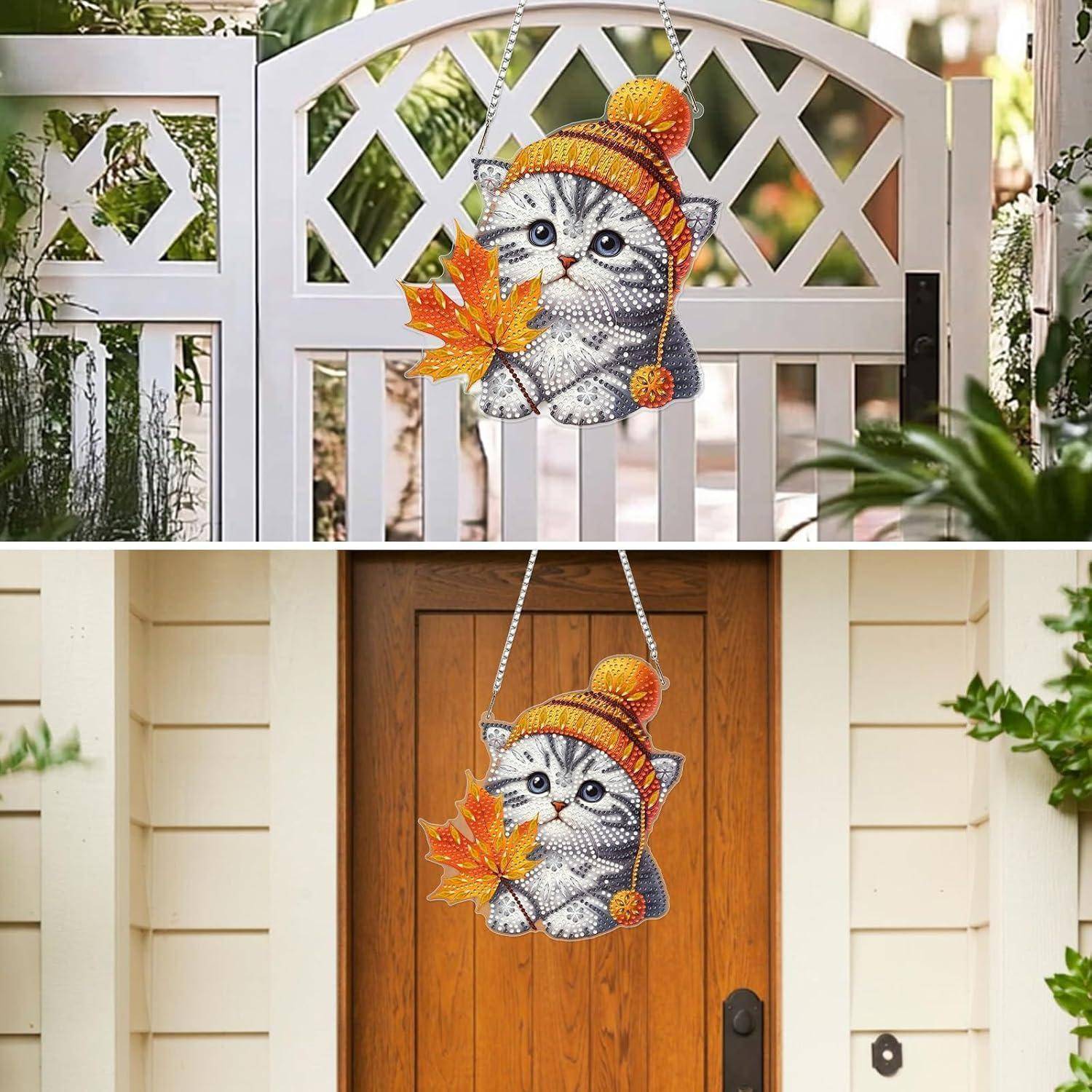 Herbstliches katzenschönes Hängdekoration an einem Tor und einer Haustür, mit gestrickter Mütze und orange Ahornblatt-Akzent.