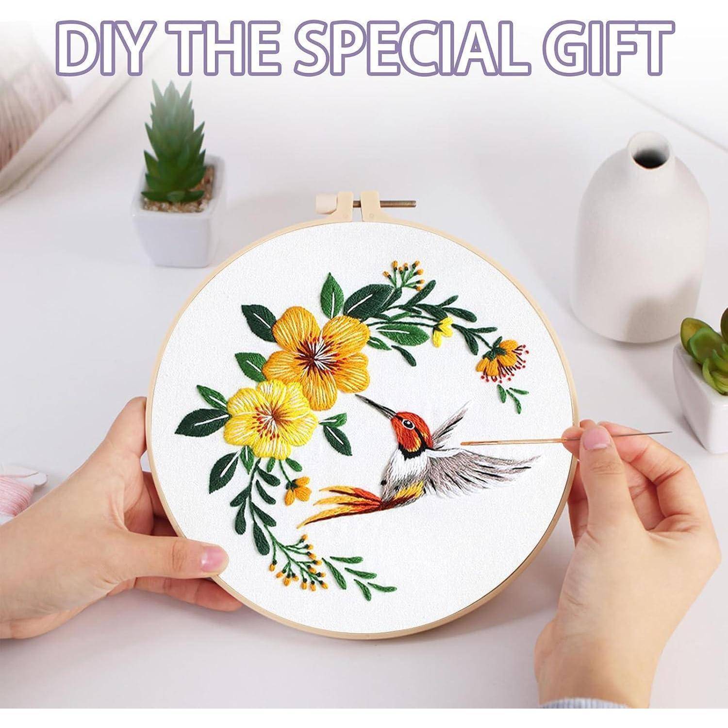 Hände besticken einen runden Rahmen mit einem Kolibri zwischen gelben Blumen mit dem Text „DIY THE SPECIAL GIFT
