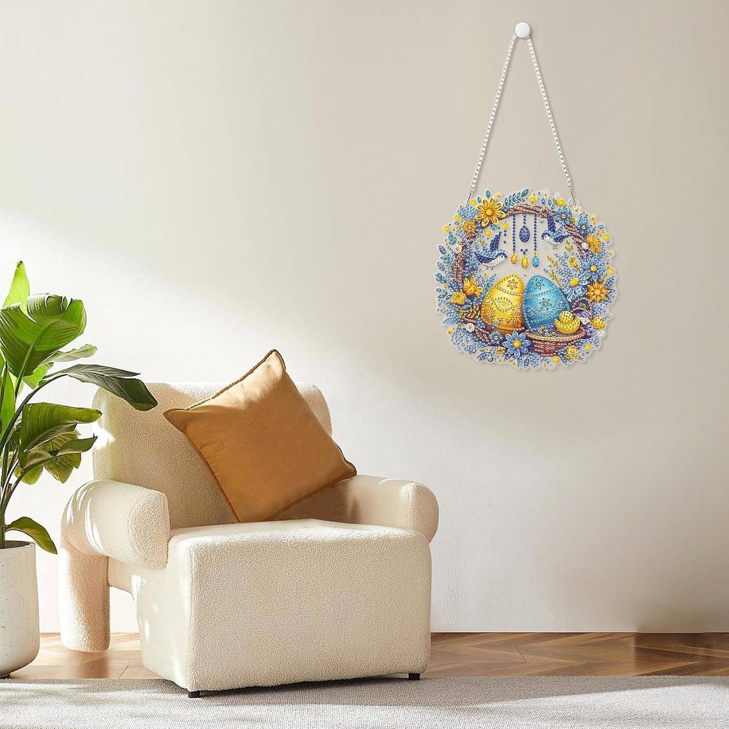 Cremefarbener Sessel in einem hellen Raum neben einer Topfpflanze, mit einem hängenden Wandornament im Oster-Stil, das mit verzierten Eiern und Blumen verziert ist.