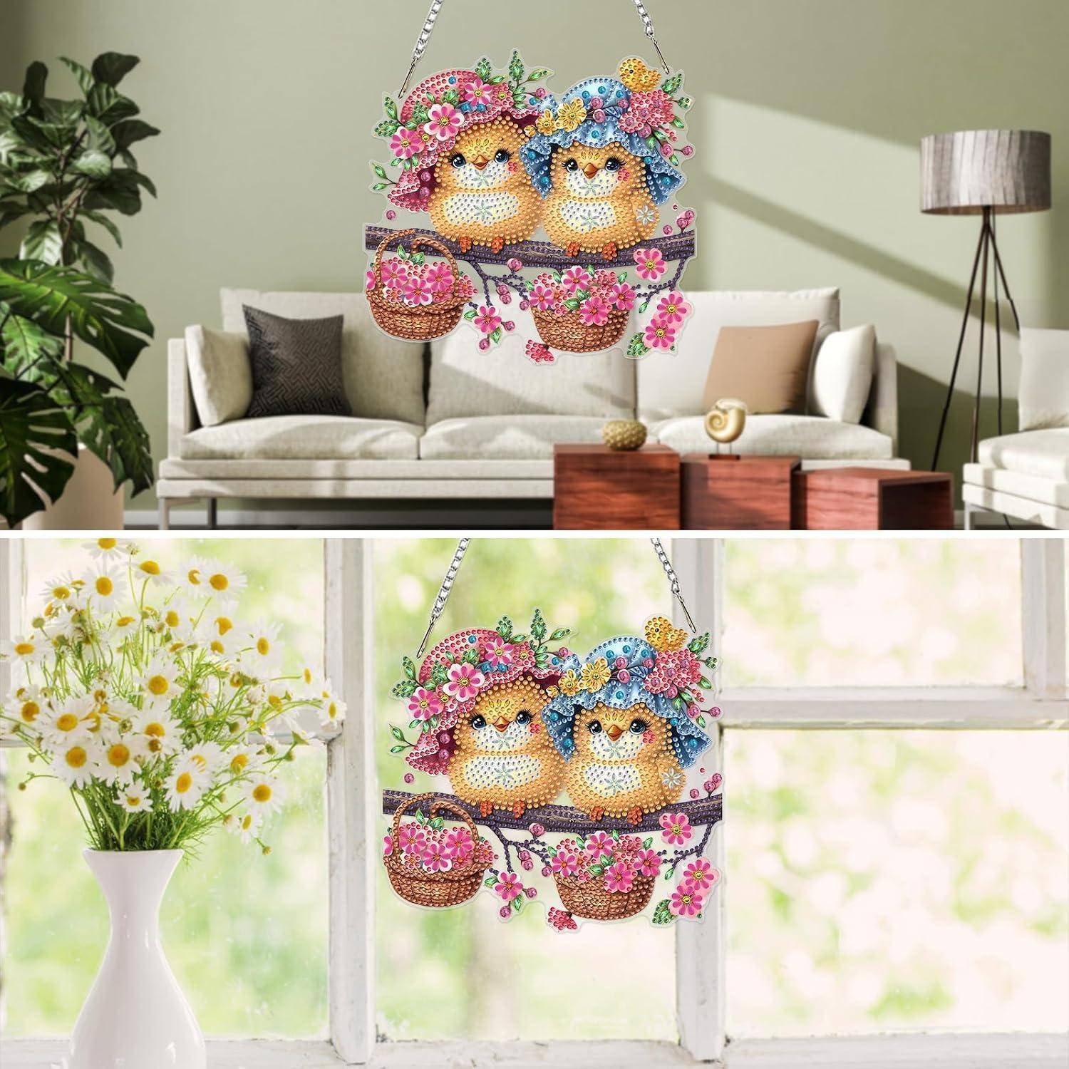 Bunte hängende dekorative Kunst mit zwei Eulen und Blumen, gezeigt in einem Wohnzimmer und an einem Fenster als helles Wandornament.
