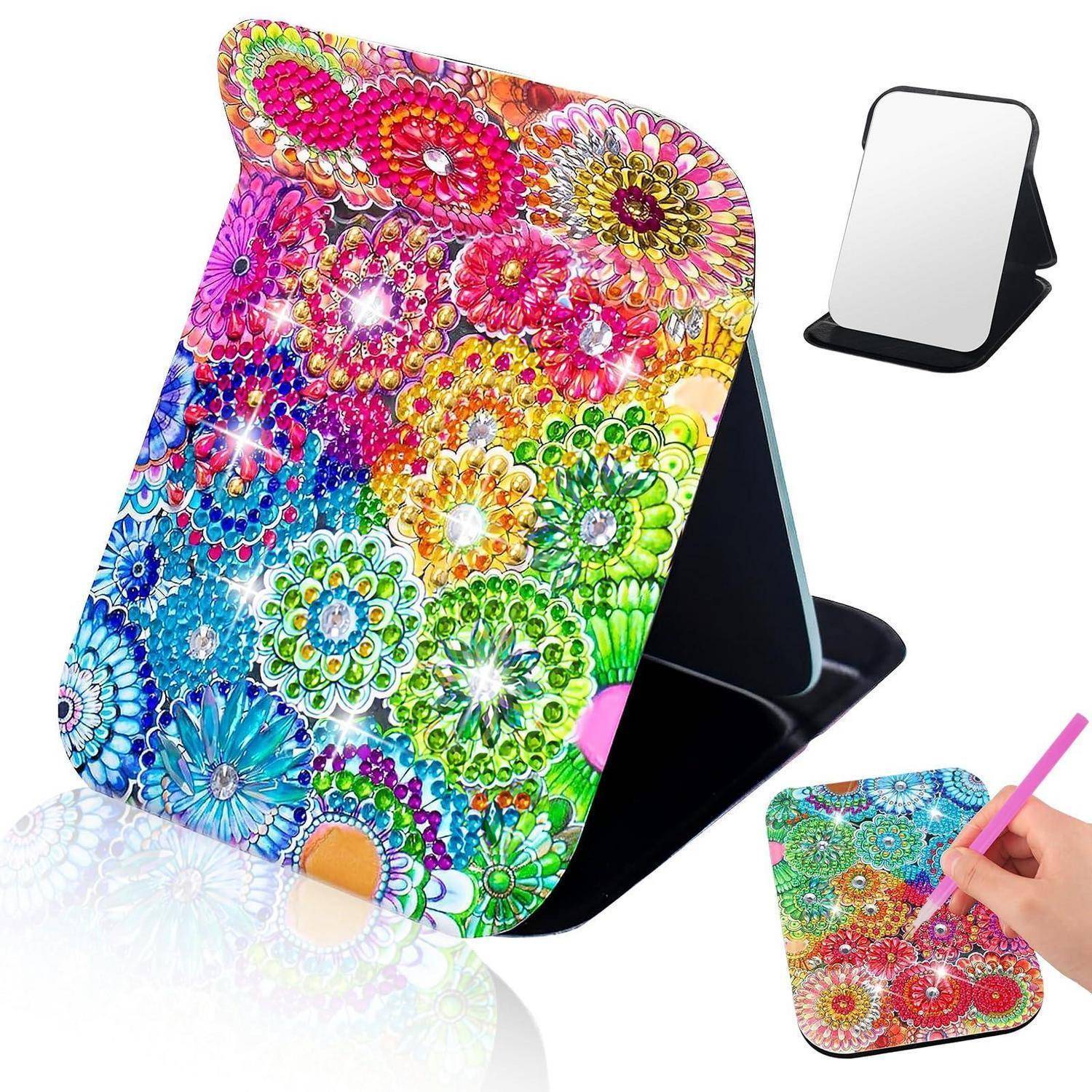 Bunter Diamantmalerei-Smartphone-Ständer zum Zusammenklappen mit Blumenmosaik-Muster, gezeigt mit einer leeren Spiegelversion und einer Hand, die einen Eingabestift zum Verzieren verwendet.