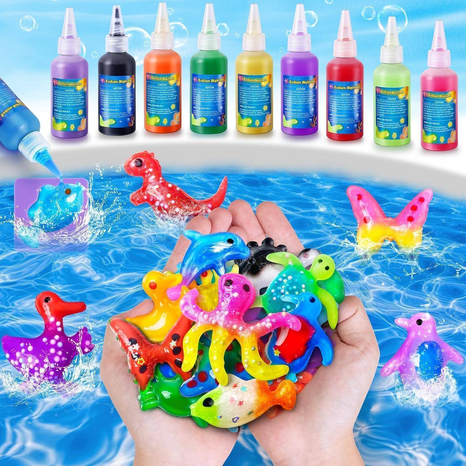 Hände halten bunte Spielzeermeerestiere in blauem Wasser, mit einer Reihe von Quetschflaschen darüber, die flüssige Farbe oder Badmalfarbe zum Spielen suggerieren.