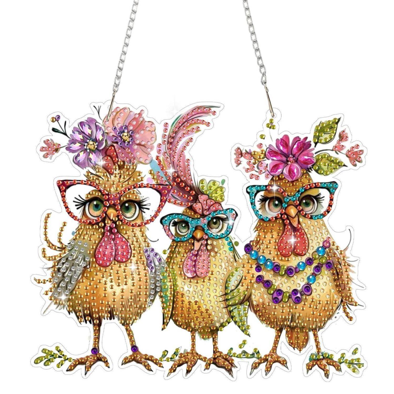 Drei geschmückte Eulenfiguren mit Blumenhüten und Hängeketten, verziert mit bunten Perlen und Pailletten.