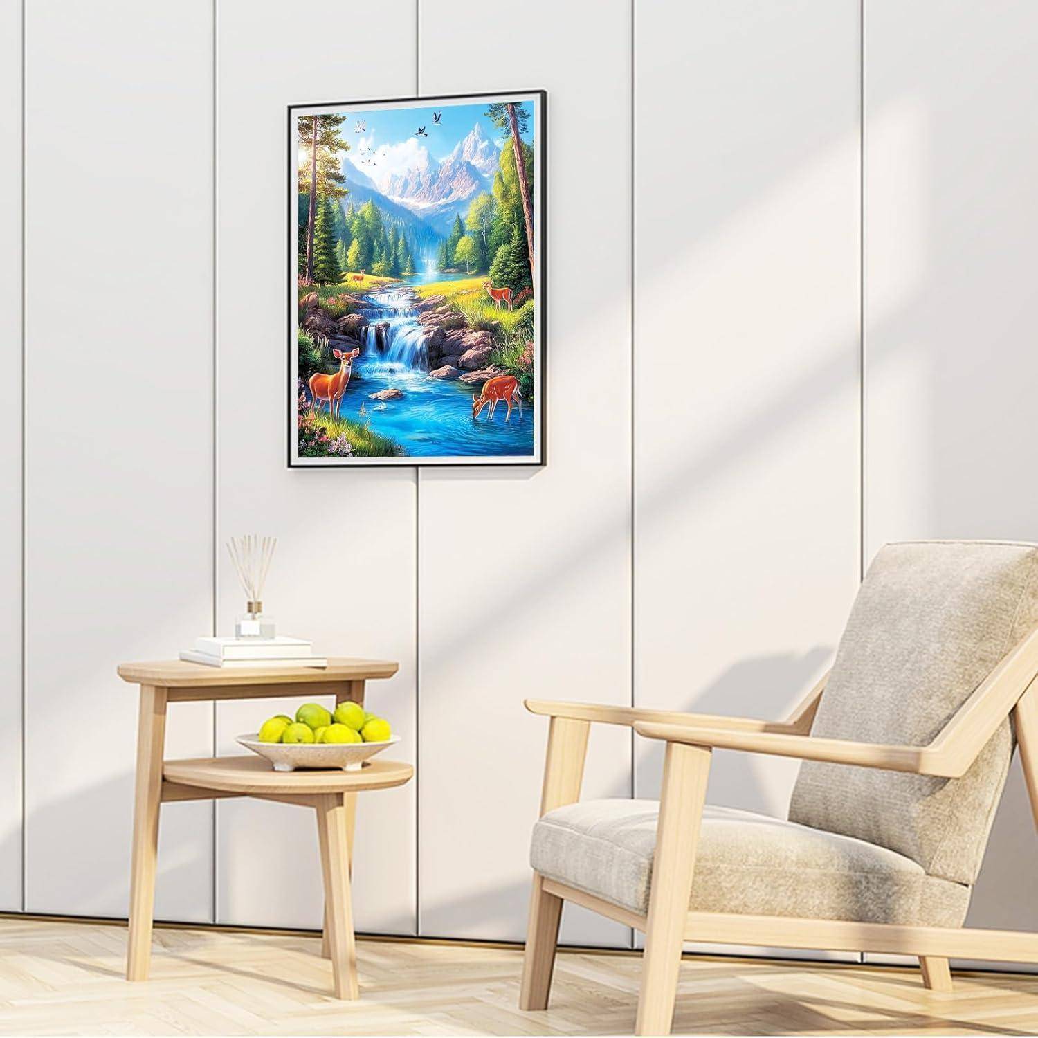 Helles Wohnzimmer mit einem gerahmten Bergwasserfalllandschaftsbild über einem Beistelltisch, der Bücher und grüne Äpfel hält, neben einem beigefarbenen Sessel.