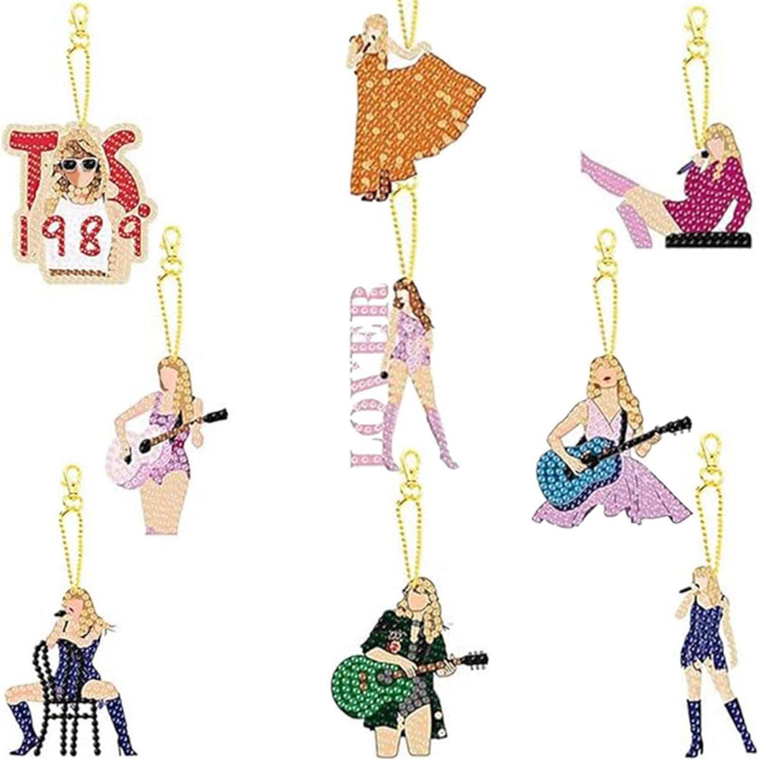 Assortierte glitzernde Ornamente weiblicher Musikerinnen und Performerinnen mit goldenen Aufhängeschleifen, einschließlich Gitarristinnen, einer Pianistin, einer Tänzerin und einer Sängerin.