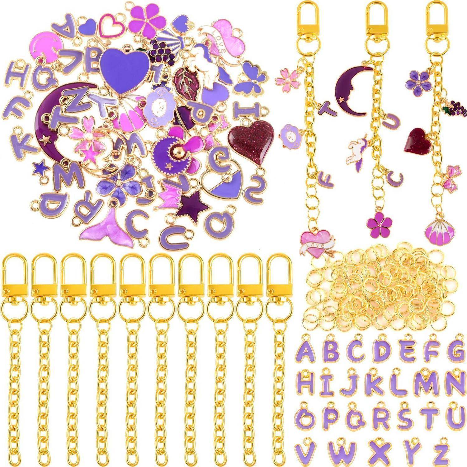 Assortierte Goldkettenverzierungen und lila Emaillbuchstaben, Herzen, Blumen und Monde zum Schmuckdesign oder zur Individualisierung.