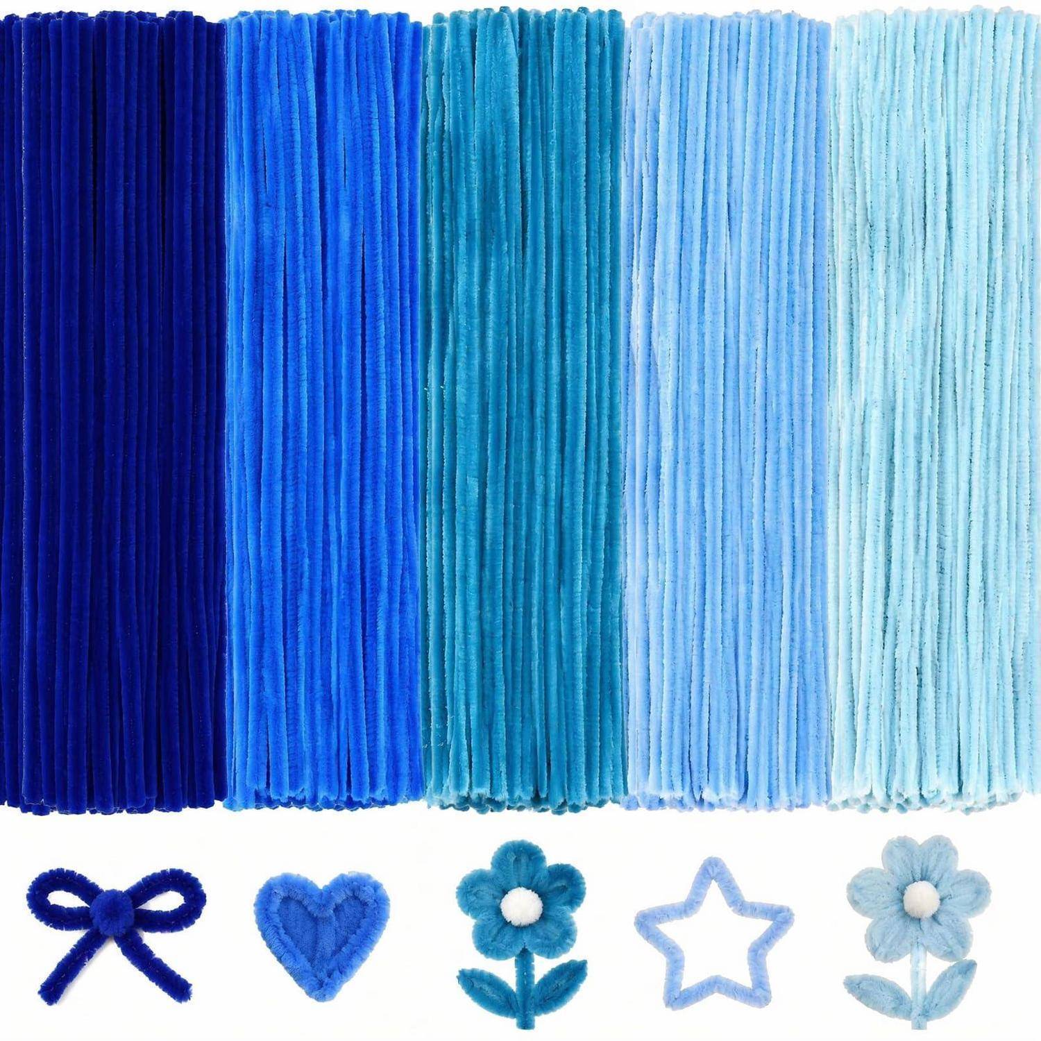 Blaue Garnmuster, gezeigt als fünf hängende Fransen-Farbmuster von dunkelblau bis hellblau, mit passenden kleinen Garnformen: Schleife, Herz, Blume, Stern und Gänseblümchen.