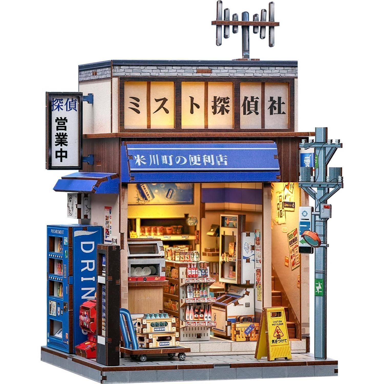 Miniatur-Diorama einer japanischen Straßenfront mit einer Detektei und einem Convenience Store, mit Schildern, auf denen „ミスト探偵社