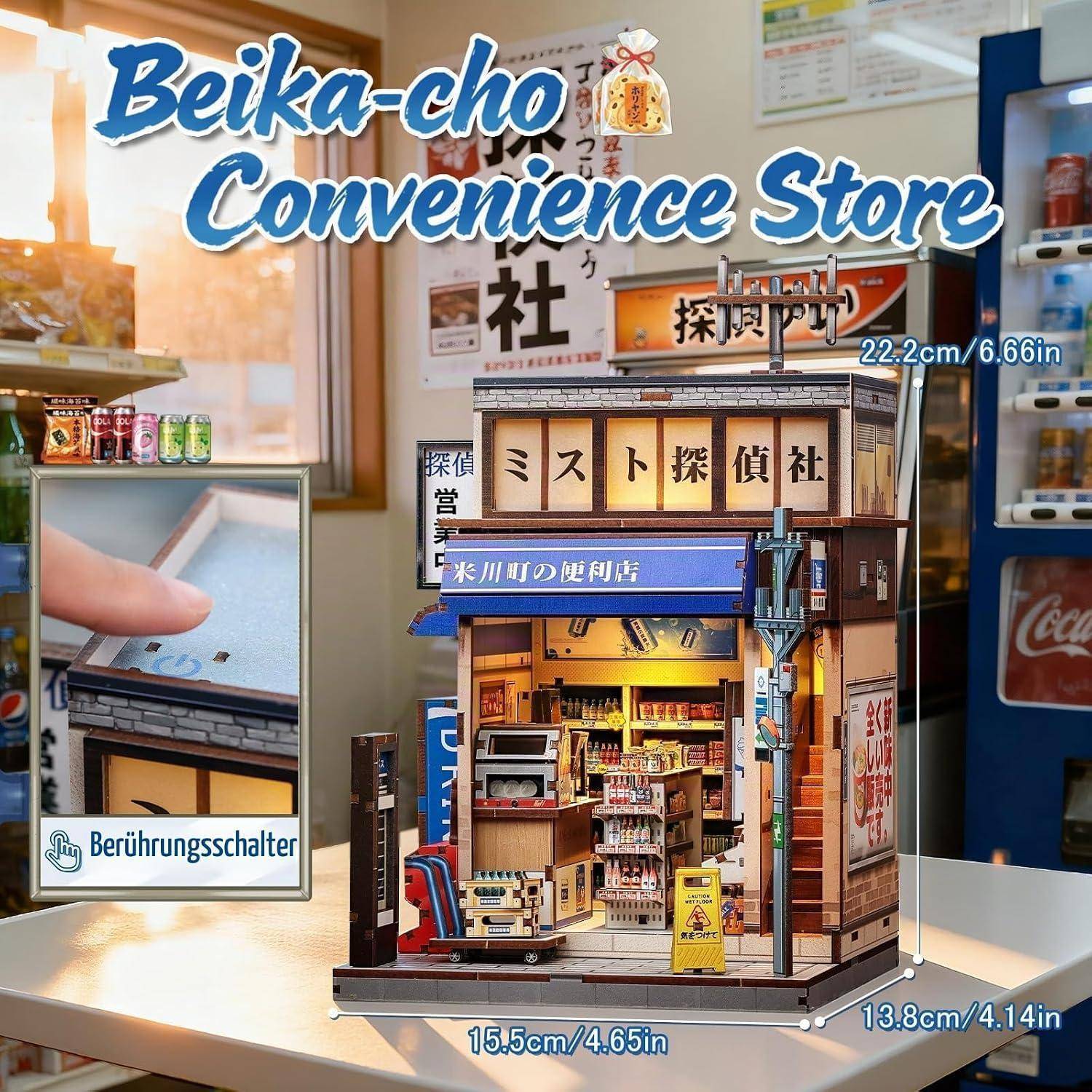 Miniatur-Modell eines Beika-cho-Convenience-Stores auf einem Tisch, mit japanischen Schildern und einem Touch-Schalter-Detail in der Vergrößerung.