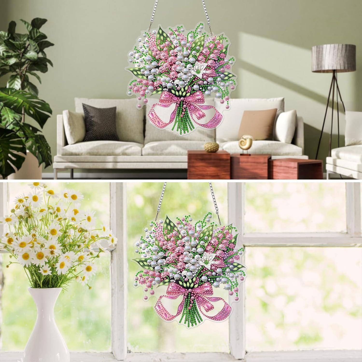 Dekorativer hängender Blumenstrauß mit rosa und weißen Blüten, gezeigt in einem Wohnzimmer und am Fenster, was auf Wohnungsdekoration oder Geschenkdekoration hindeutet.