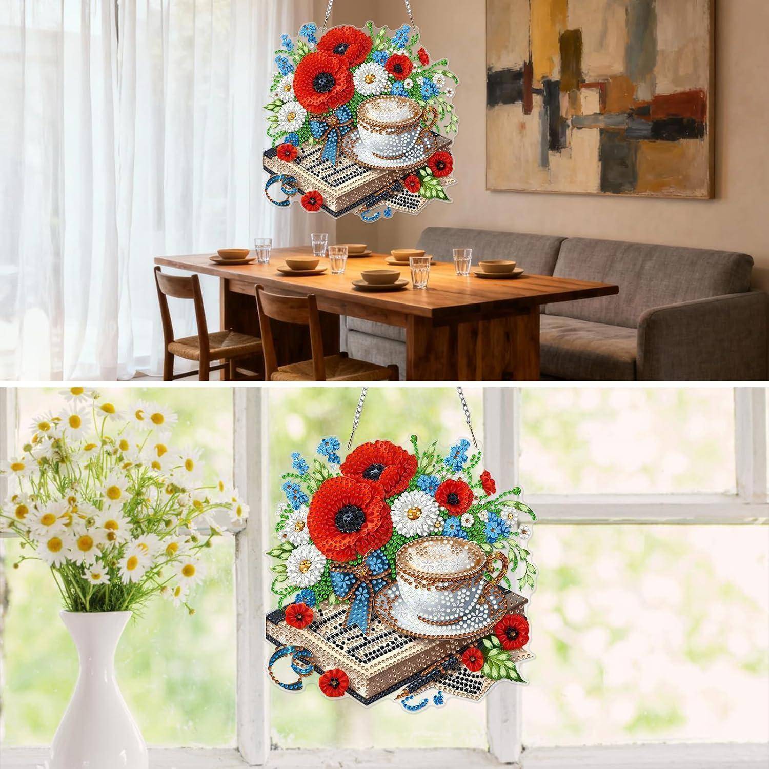 Behangter Schmuckanhänger in Form einer Teetasse aus Perlen auf Büchern mit roten Blumen, in einem hellen Zimmer über einem Esstisch ausgestellt.