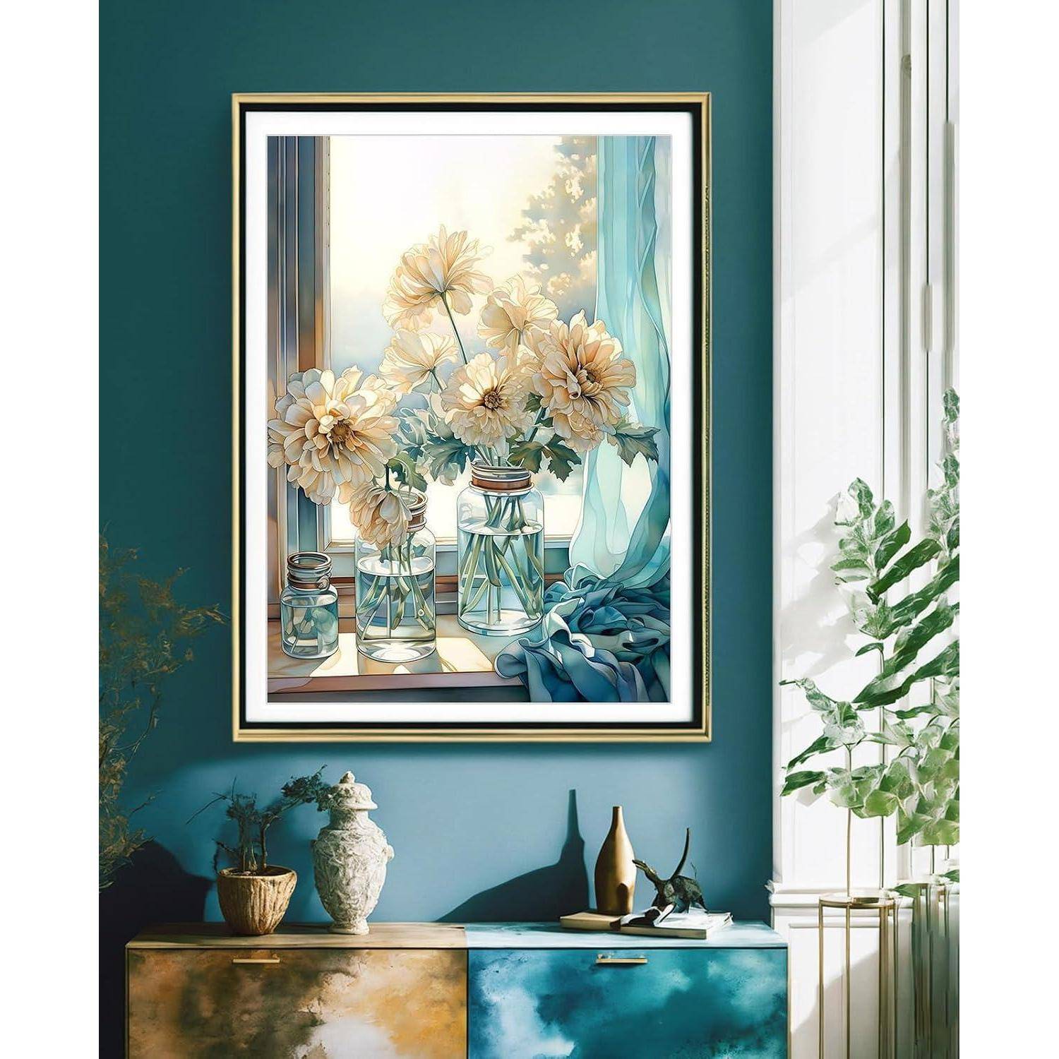 Gerahmtes Stillleben mit weißen Blumen in Glaskrügen auf einem Teakfarbenen Sideboard in einem hellen Zimmer neben einem Fenster.