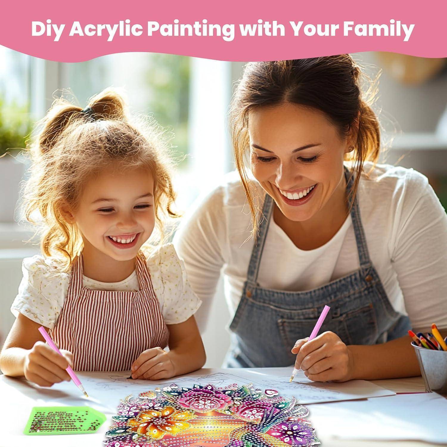 Mutter und kleine Tochter lächeln, während sie an einem Tisch an einem Acrylgemälde malen, mit dem Titel „DIY-Acrylmalerei mit Ihrer Familie" oben.