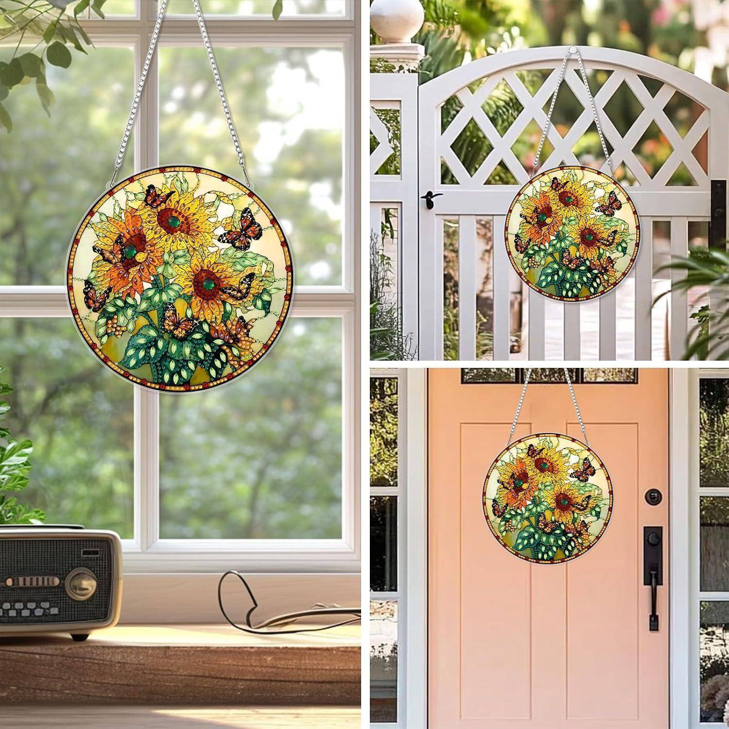 Rundes Sonnenblumen- und Schmetterlingsbemaltes-Glaspaneel, das an einer Kette im Fenster hängt, gezeigt als dekorative Innen- und Türdekoration.