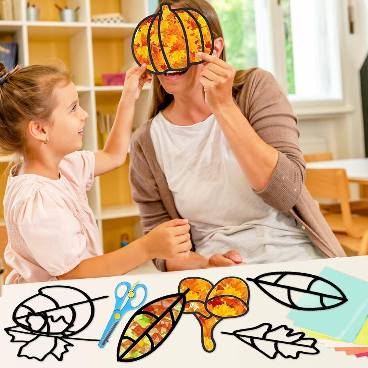 Kind und Frau basteln Herbstblatt-Sonnenfänger an einem Tisch, mit ausgeschnittenen Blattvorlagen und Schere in einer Klassenzimmer- oder Heimatmosphäre.