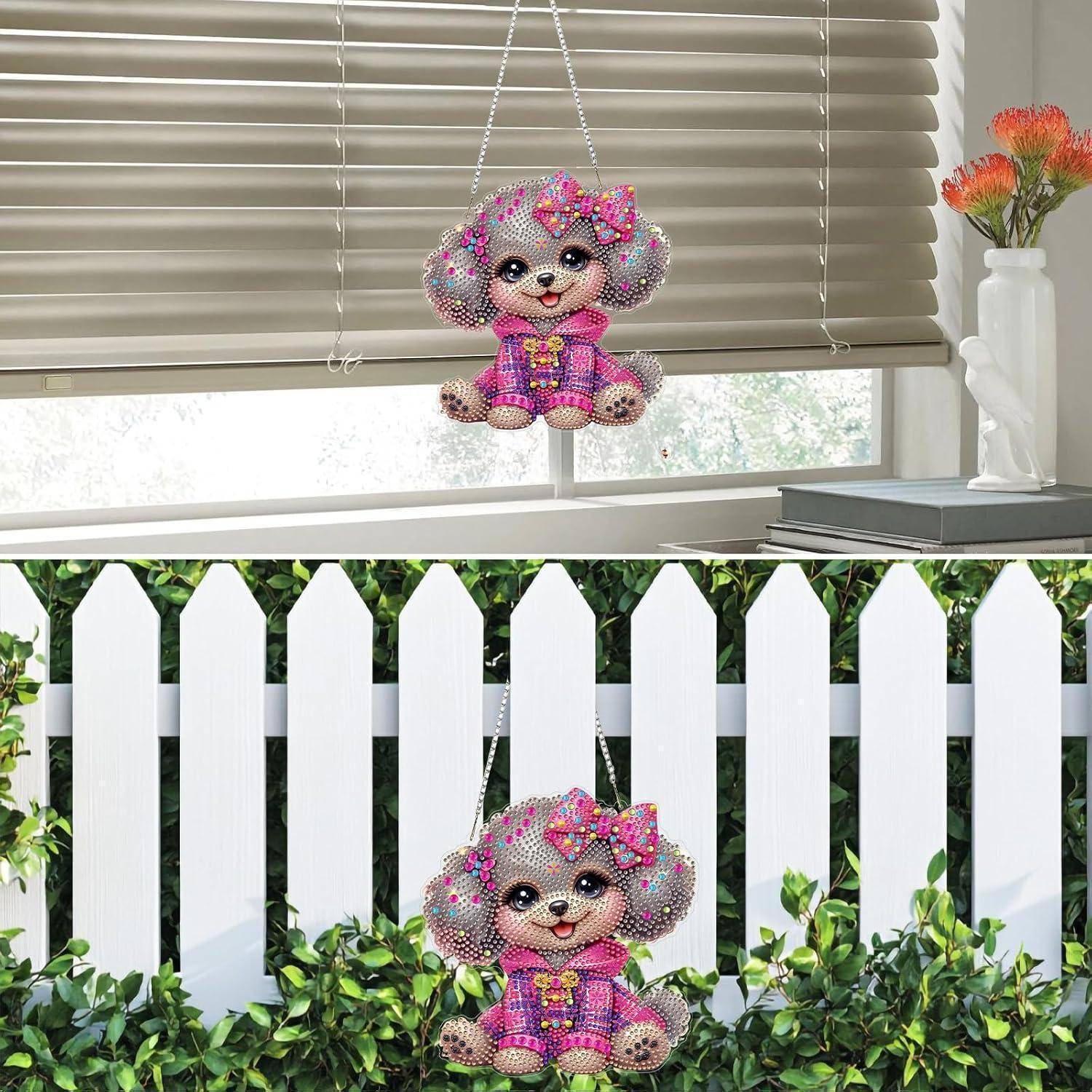 Ein glitzernd rosa Cartoon-Hundeornament mit Schleifen und Kleid wird hängend in einem Fenster und auf einem weißen Lattenzaun im Freien ausgestellt gezeigt.