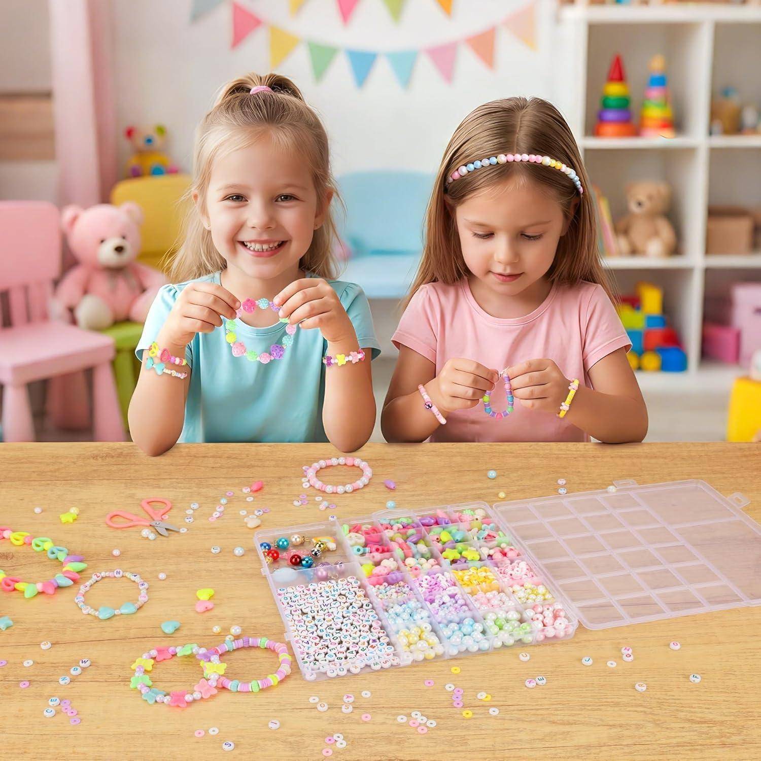 Zwei junge Mädchen fertigen bunte Perlenarmbänder an einem Tisch mit Bastelmaterialien in einem Spielzimmer an.