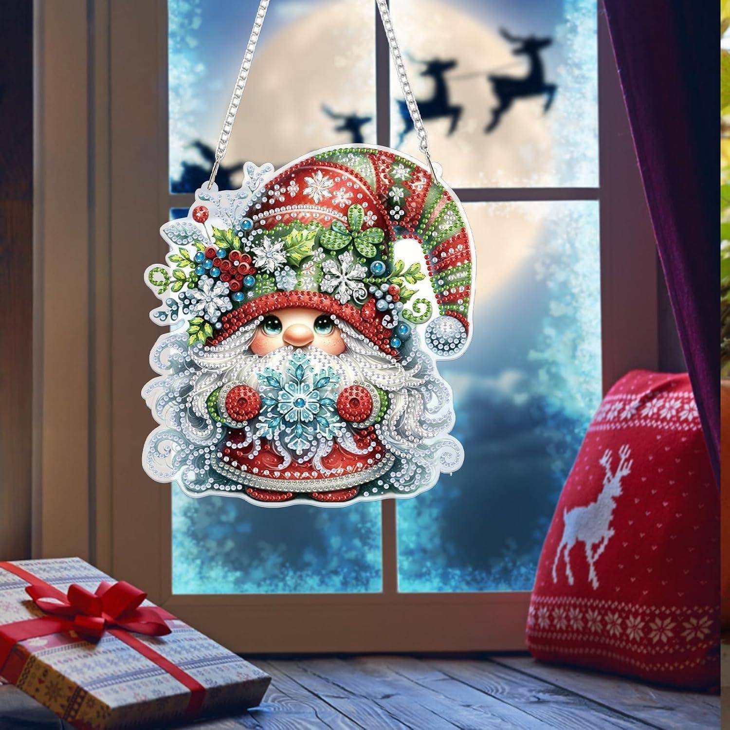 Dekoratives Weihnachtsmann-Gesicht-Weihnachtsornament mit Schneeflocken-Bart hängt in einem Fenster; eingewickeltes Geschenk und rote Rentier-Pullover-Tasche sitzen in der Nähe, mit schneebedeckter Außenszene dahinter.