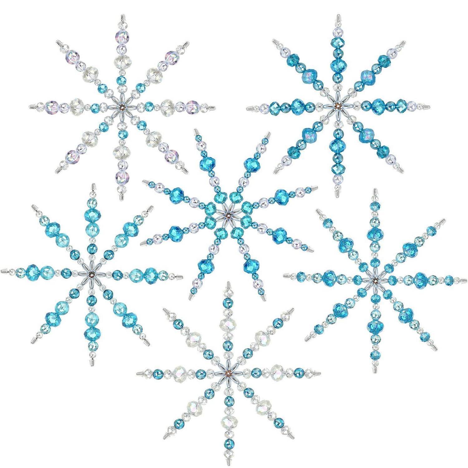 Fünf dekorative Schneeflockenornamente aus blauen und klaren Perlen auf weißem Hintergrund angeordnet.
