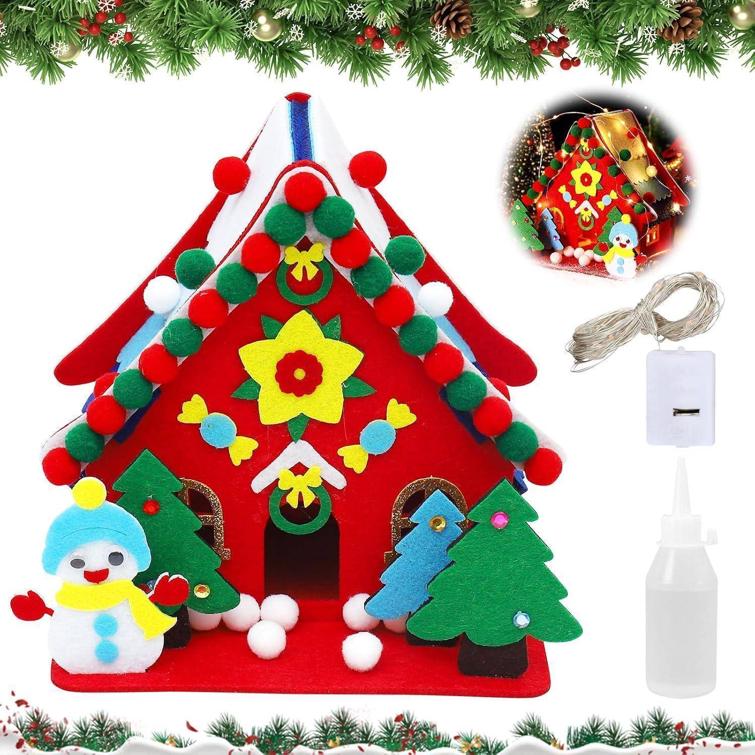 DIY Filzhaus-Weihnachtsbastelset mit Schneemann, Bäumen, Pompom-Borte, Lichterkette und Flasche Klebstoff, gezeigt mit einem fertigen Beispiel.