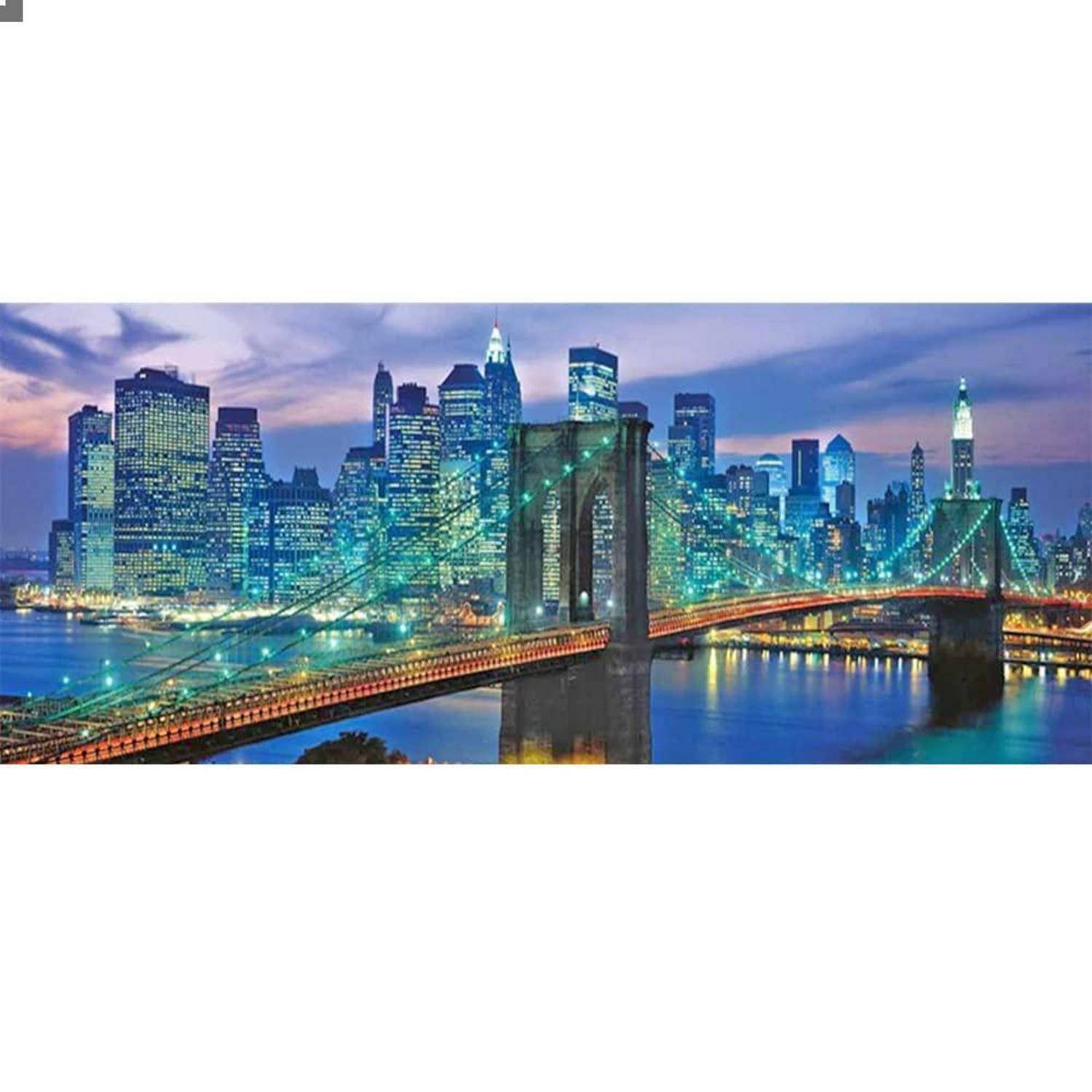 Hängebrücke, die einen Fluss vor einer beleuchteten Stadtskyline in der Dämmerung überquert, mit illuminierten Türmen und Spiegelungen im Wasser.