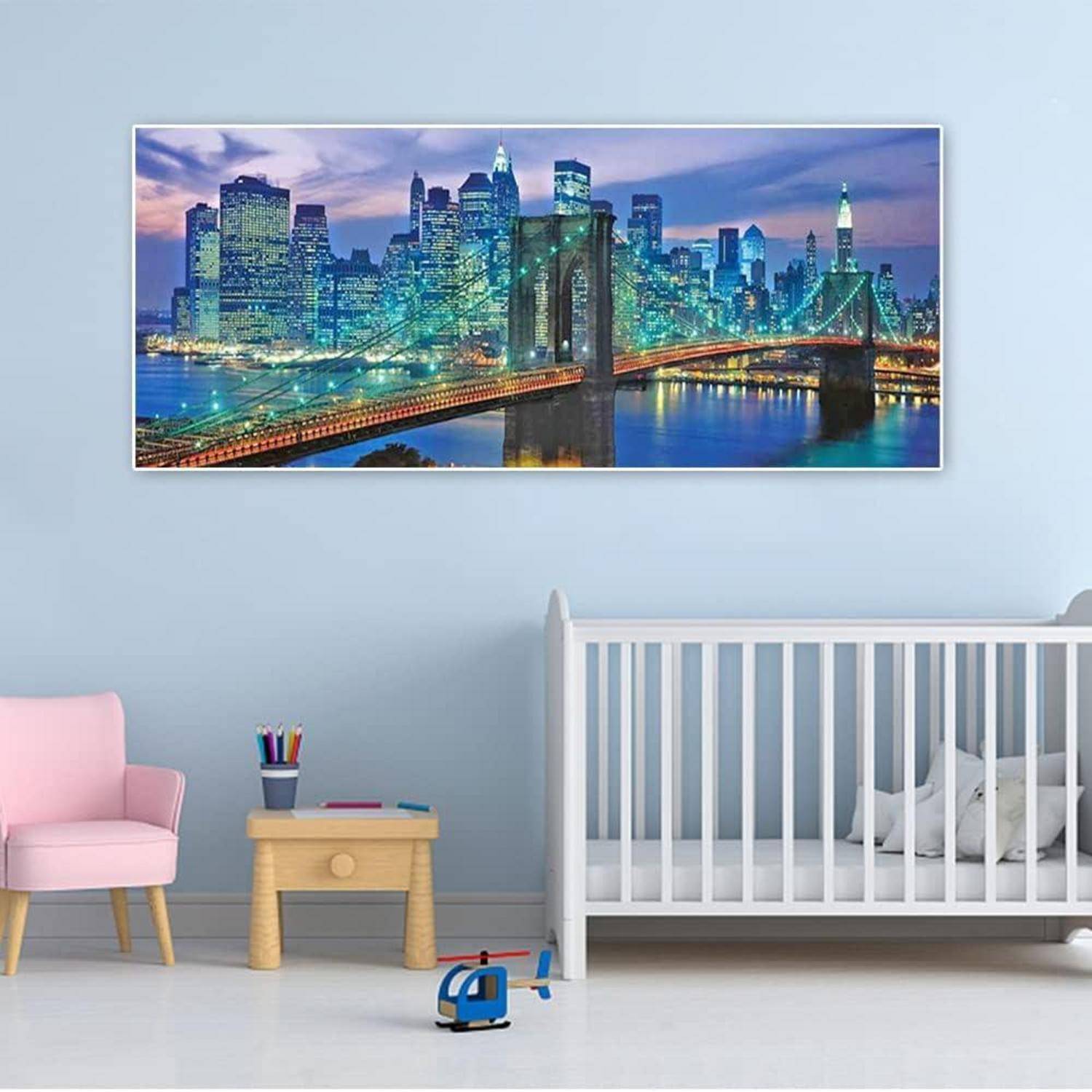 Kinderzimmer mit einem Gitterbett, rosa Stuhl, Spielzeugtisch und Helikopter-Spielzeug, mit einem gerahmten Druck einer Stadthimmelssilhouette mit Brücke an der Wand.