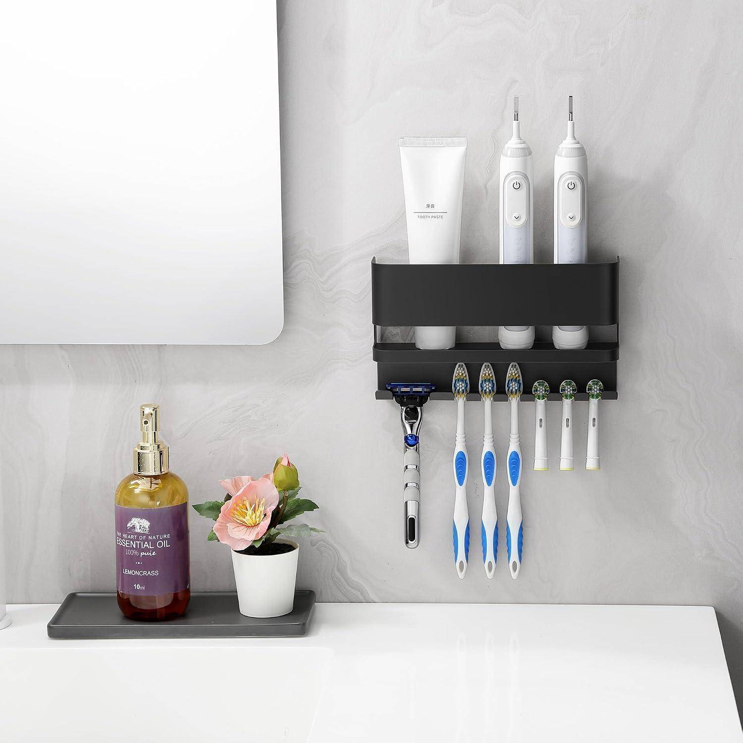 Badezimmer-Wandorganizer, der elektrische Zahnbürsten, manuelle Zahnbürsten, einen Rasierer, Zahnpasta und zwei elektrische Bürsten über einem Waschbecken und einer Arbeitsplatte hält.