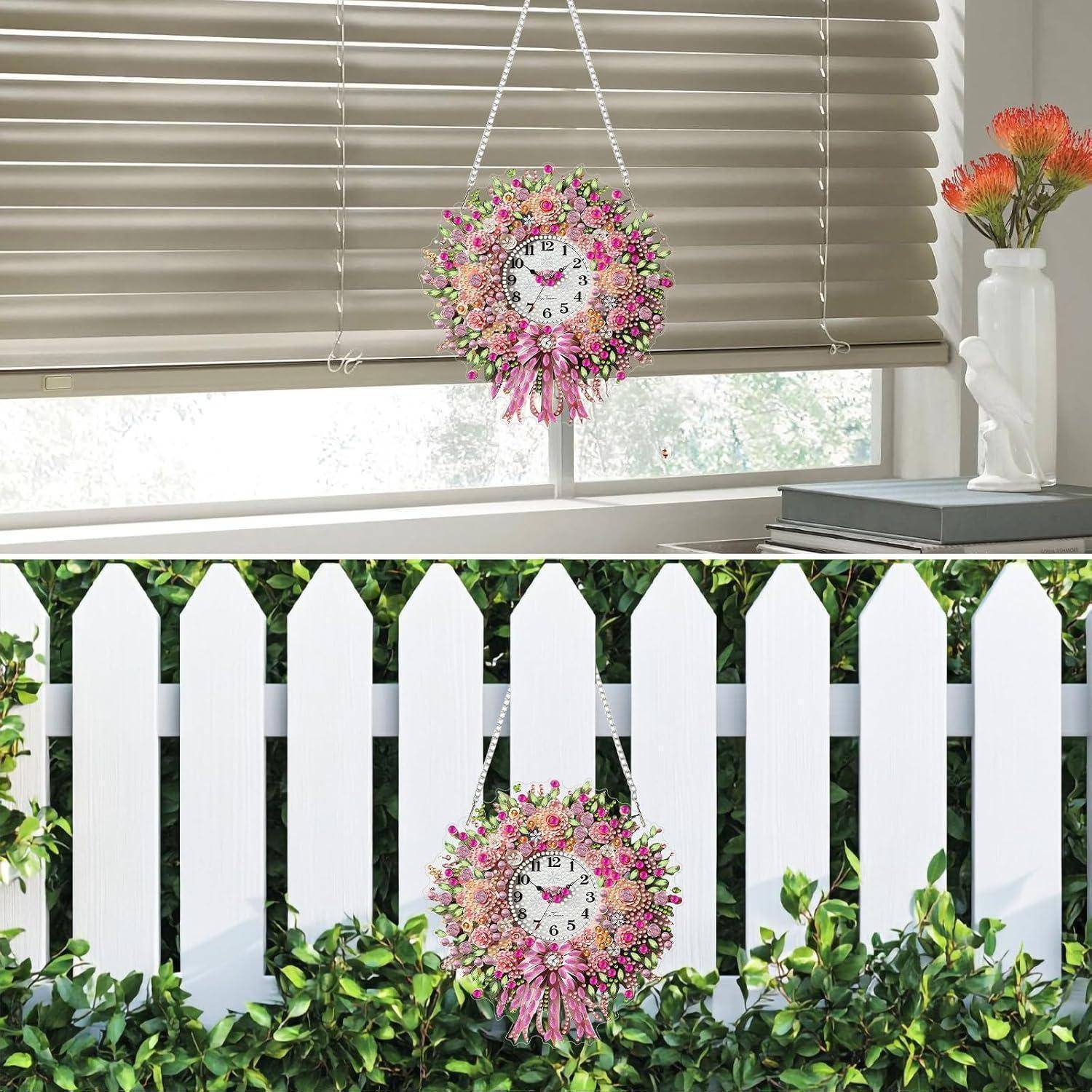 Dekorativer Blumenkranz-Uhr, der vor einem Fenster und einem weißen Lattenzaun hängt, oben drinnen und unten draußen gezeigt.