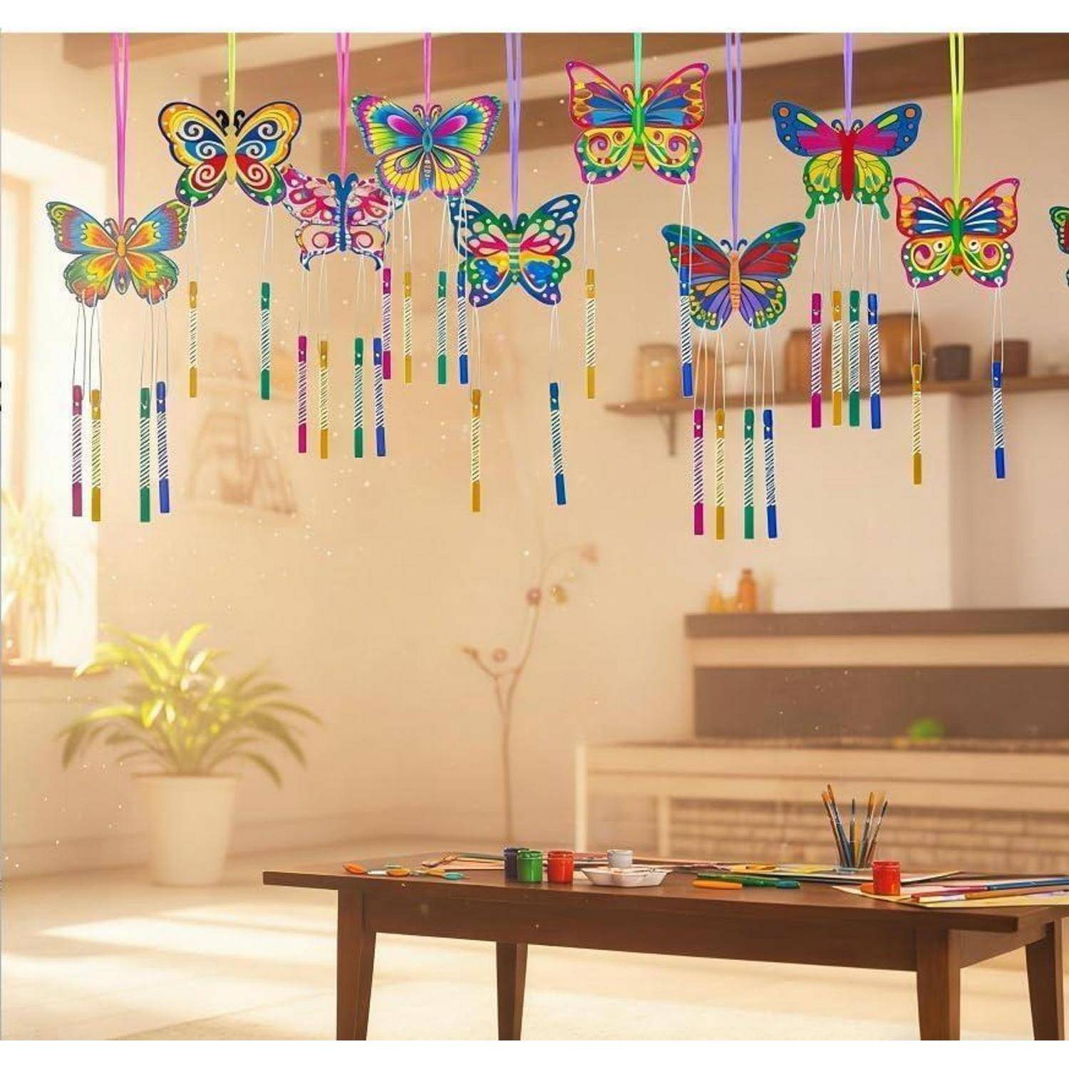 Bunte Schmetterlingswindspiele hängen in einem Innenraum über einem Basteltisch in einem hellen, sonnendurchfluteten Zimmer.
