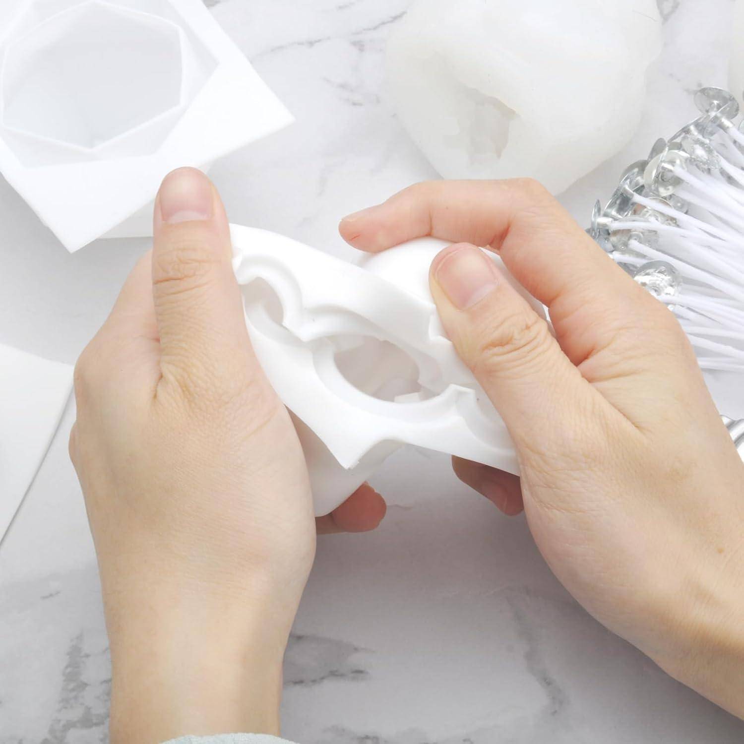Hände, die eine weiße Kunststoffform oder einen Rahmen über einer Marmoroberfläche halten und biegen, mit Schaumstoff- oder Verpackungsteilen in der Nähe.