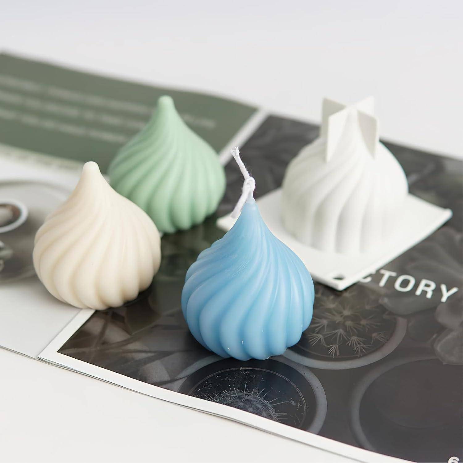 Vier dekorative Spiralkerzen in Creme, Grün, Blau und Weiß, angeordnet auf bedruckten Karten, dargestellt als Produktpräsentation.