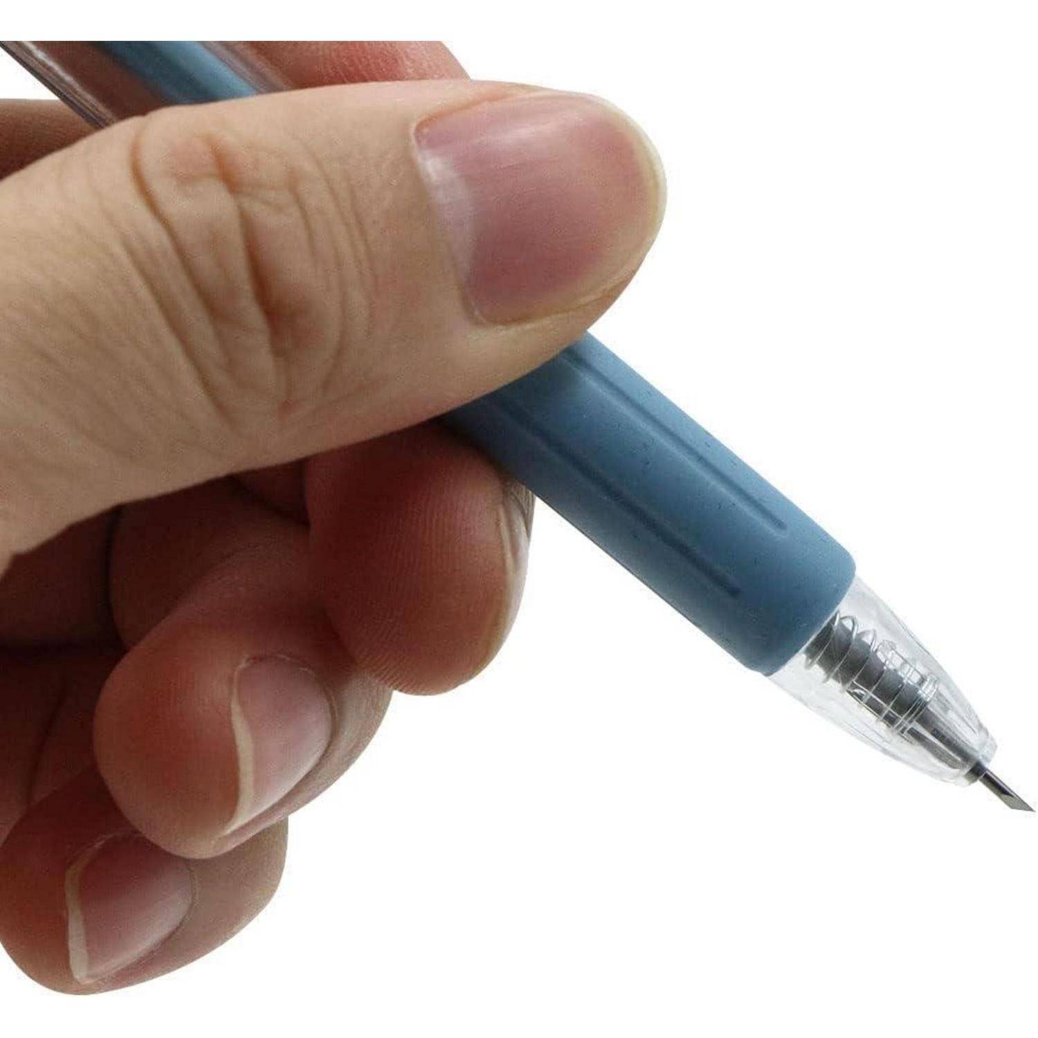 Nahaufnahme einer Hand, die einen blauen Stift mit transparenter Spitze und Metallpunkt hält, im Winkel nach unten gegen einen schlichten weißen Hintergrund gerichtet.