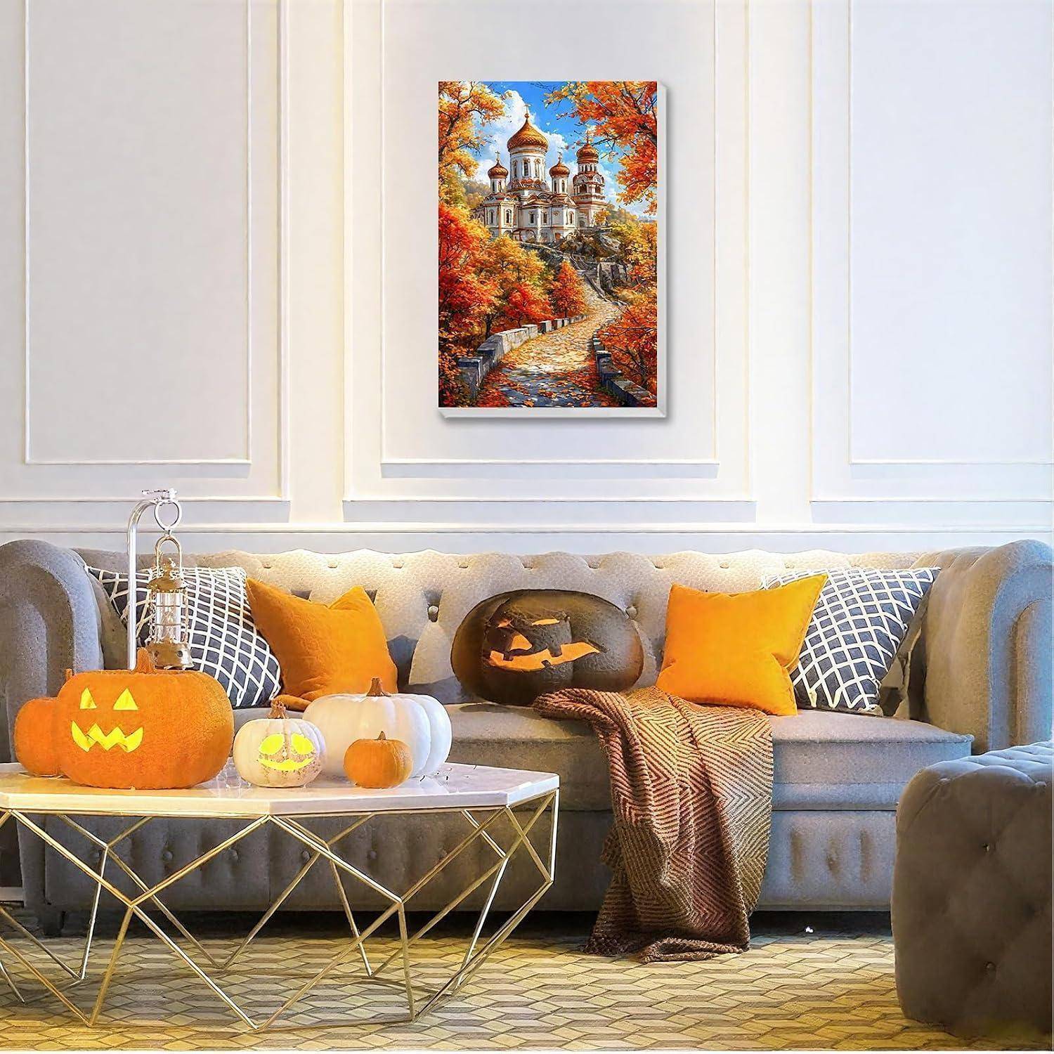 Gemütliches Wohnzimmer, das für Halloween dekoriert ist, mit Kürbissen auf einem Couchtisch, orangefarbenen Kissen und einem Herbstlandschaftsgemälde über dem Sofa.