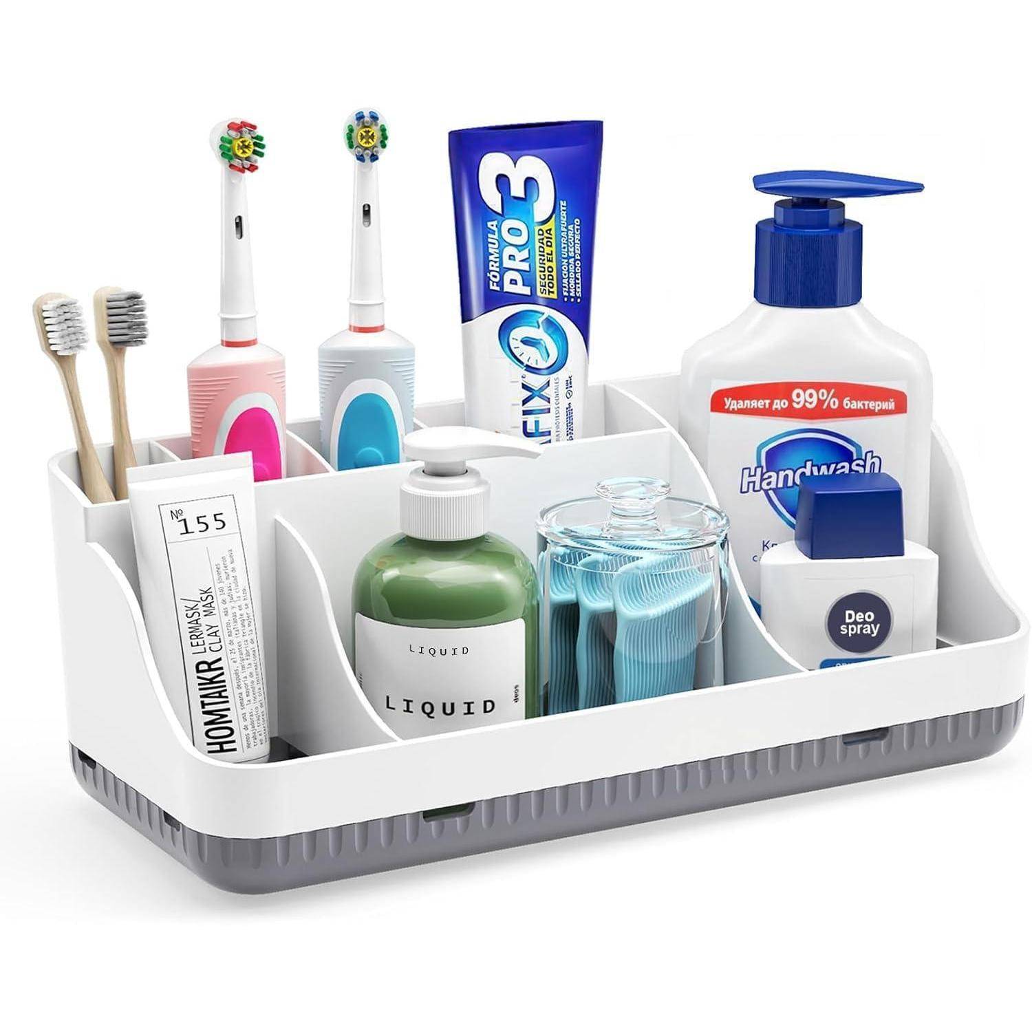 Weißes Badezimmer-Organizer-Tablett mit Zahnbürsten, Zahnpasta, Handseife, Seife, Deodorant und einem Rasierer in separaten Fächern.