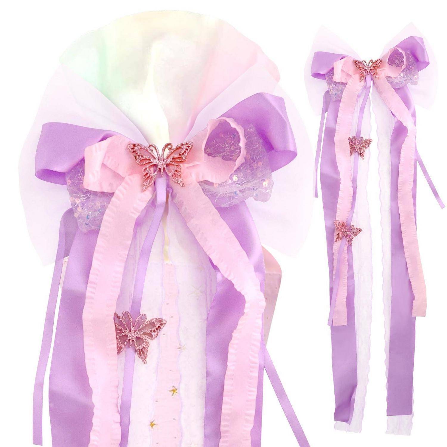 Pastellfarbene lila und rosa Schleifen mit Schmetterlingsakzenten und langen Bändern, gezeigt als dekoratives Haaraccessoire auf weißem Hintergrund.
