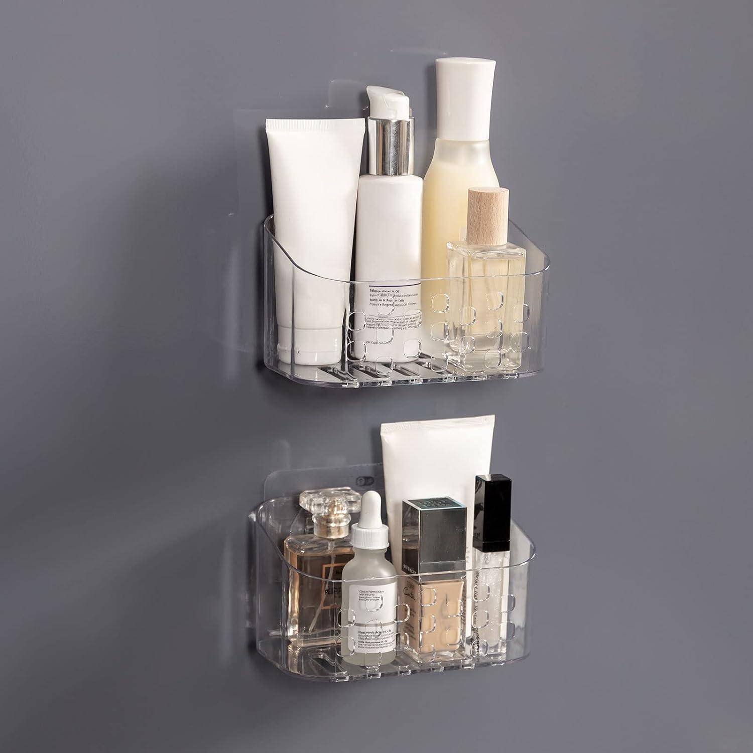 Zwei transparente, wandmontierte Acryl-Organizer halten verschiedene Hautpflege- und Beauty-Flaschen und Tuben an einer grauen Wand.