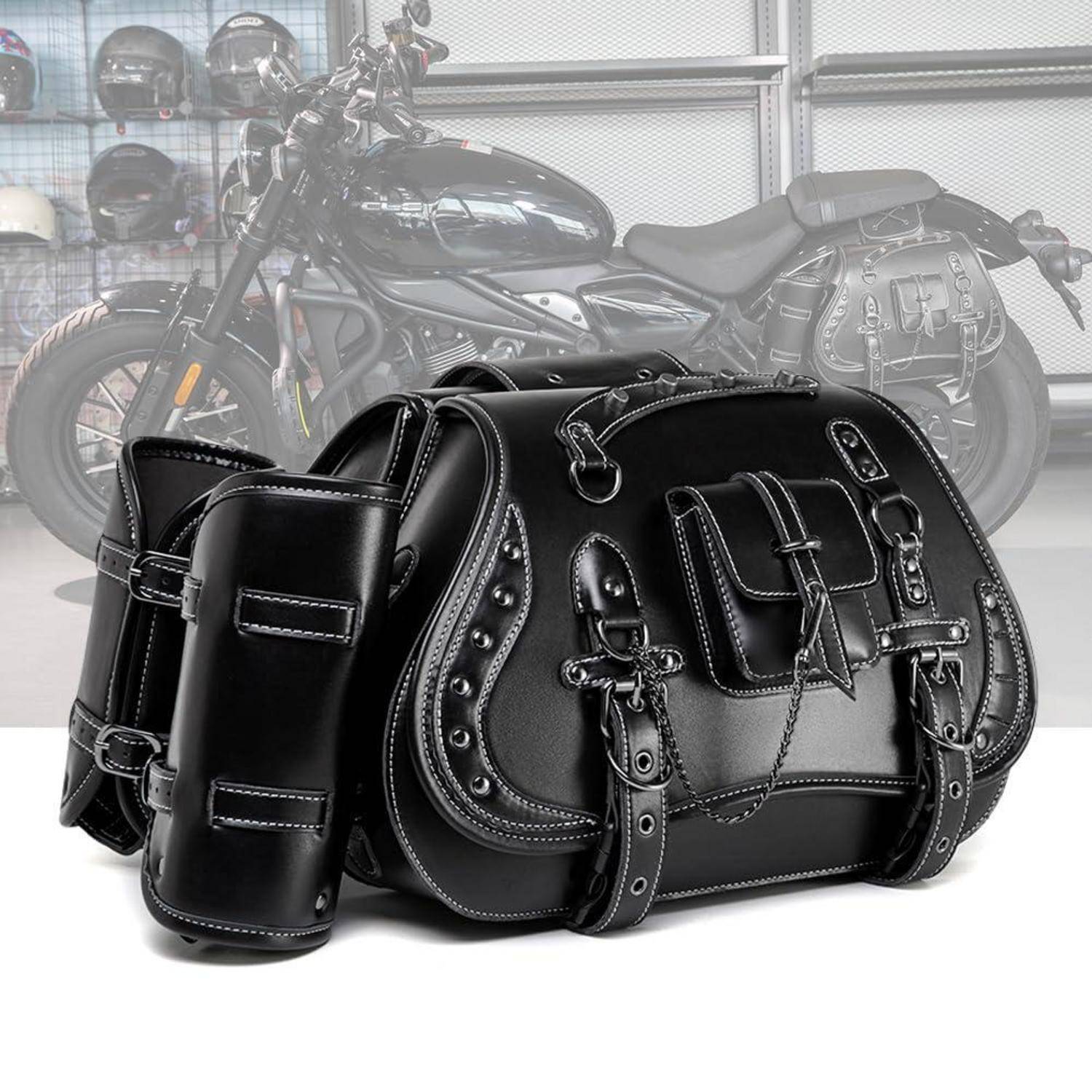 Schwarze Ledermotorrad-Satteltaschen und passende Werkzeugtaschen, die vor einem Cruiser-Motorrad in einer Garage oder einem Showroom gezeigt werden.