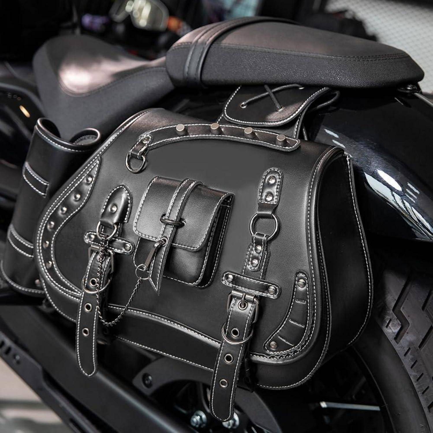 Schwarze Ledermotorrad-Satteltasche, die auf dem Rücksitz montiert ist, mit dekorativen Riemen und Schnallen.