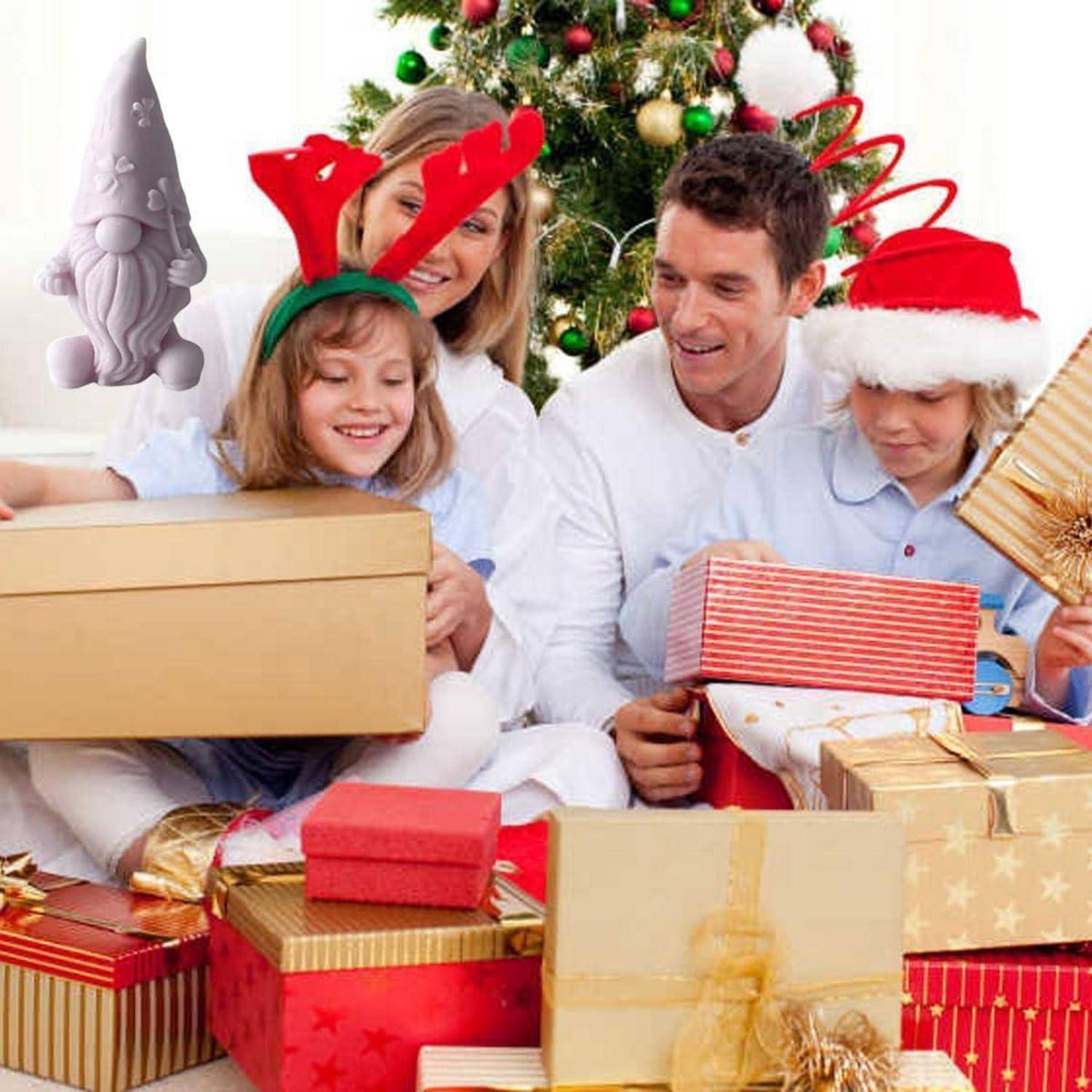 Eine lächelnde Familie in weißer Kleidung und festlicher Kopfbedeckung öffnet Weihnachtsgeschenke neben einem geschmückten Baum, mit vielen eingepackten Geschenken, die um sie herum gestapelt sind.