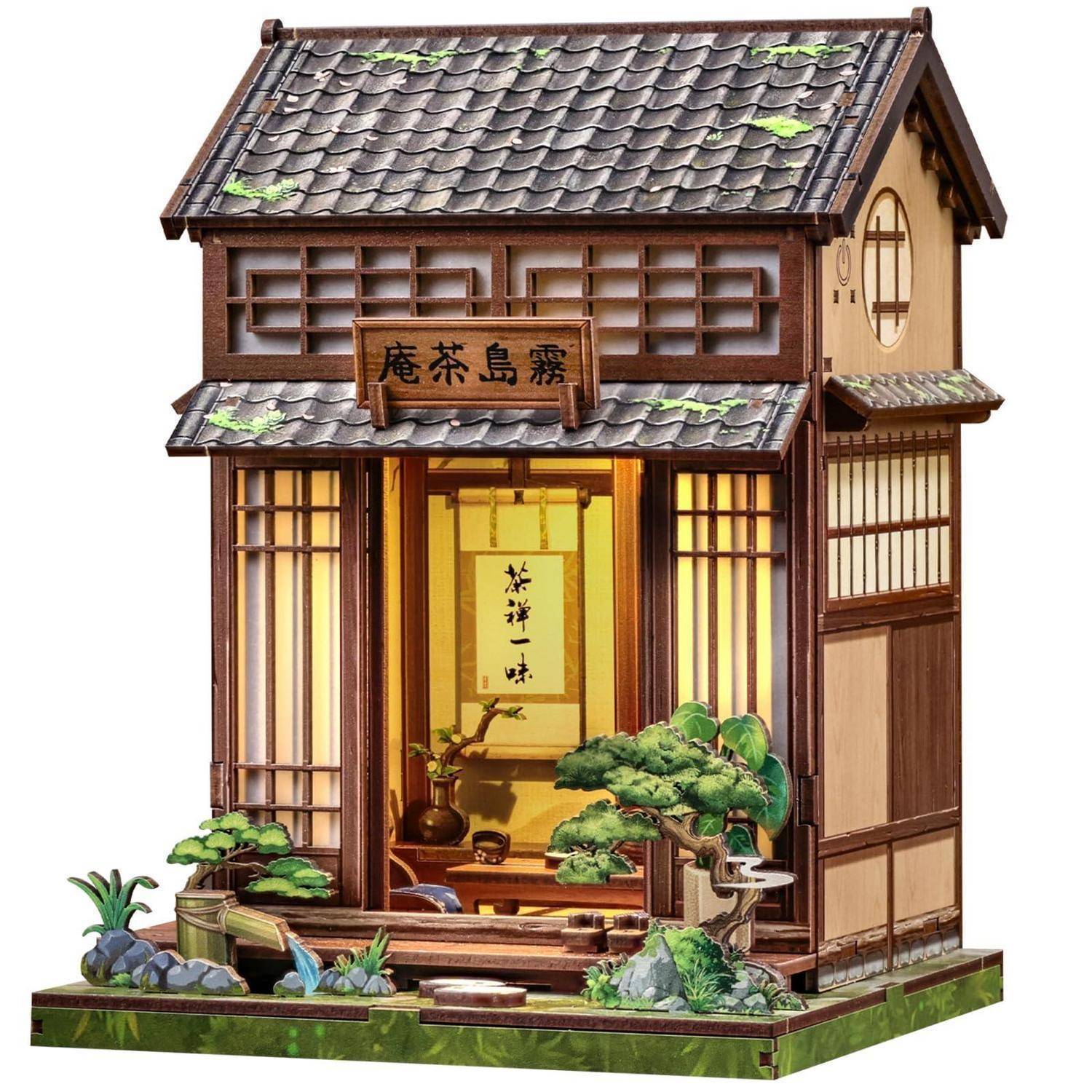 Miniatur-Japanisches Teehaus-Modell mit offener Vorderseite, hölzernen Gitterfenstern, Schiebetüren und einer Gartenszene im Inneren und rundherum.