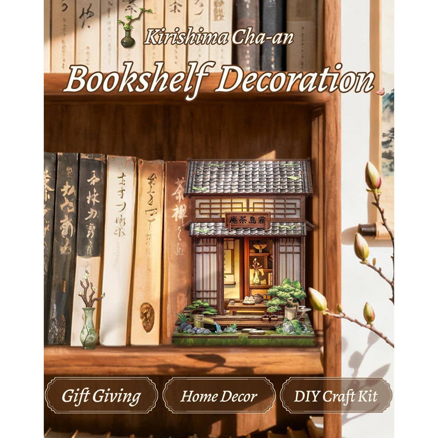 Dekorative Bücherregalanzeige mit einem miniaturartigen japanischen Ladenmodell auf einem Regal neben vertikal gestapelten Büchern, mit dem Label 'Kirishima Cha-an Bücherregal-Dekoration' und 'Geschenkgeben', 'Heimdekoration', 'DIY-Bastelset'.