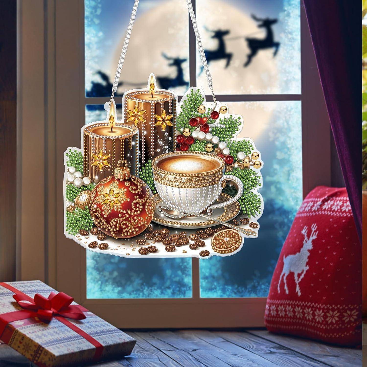 Festliches Weihnachtsornament mit Kerzen, Teetasse, Beeren und einer roten Kugel, die vor einem Fenster mit Rentiersilhouetten hängt.