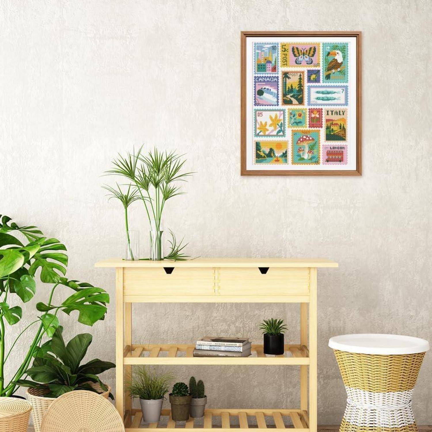 Minimalistisches Zimmer mit Topfpflanzen, einem Konsolentisch aus hellem Holz, einer gerahmten Briefmarkenkollagen an der Wand und einem geflochtenen Beistelltisch.