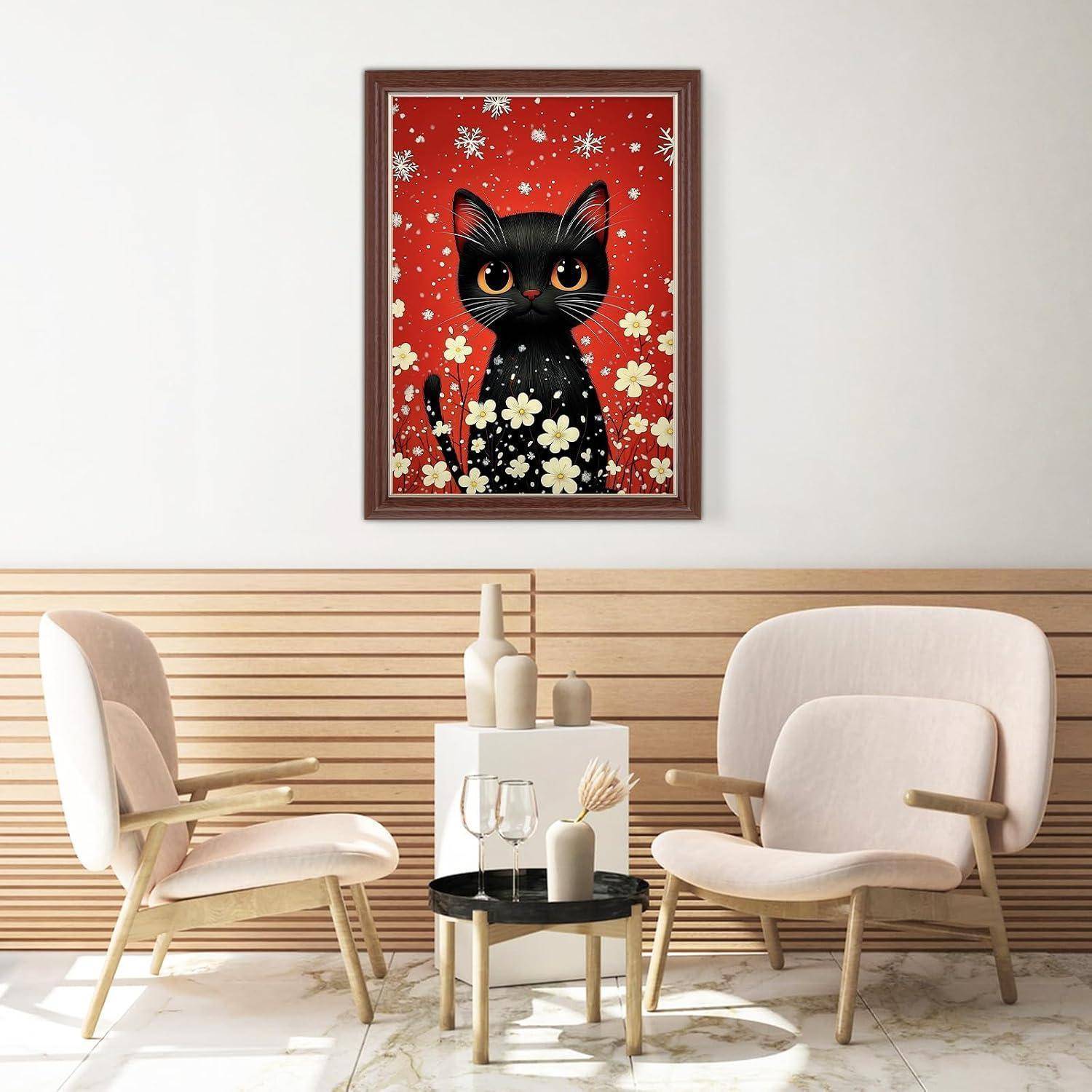 Gerahmtes Kunstwerk einer schwarzen Katze auf rotem Blumenhintergrund hängt über einem modernen Sitzbereich mit zwei beigen Stühlen und einem kleinen Tisch.