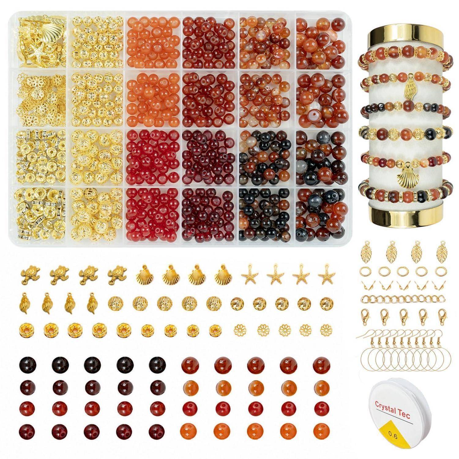 Sortiertes Schmuckherstellungs-Perlen- und Charm-Set mit goldenen, roten, orangefarbenen und schwarzen Perlen, Abstandshaltern, Muscheln, Sternen, Ringen und einer beispielhaften gestapelten Armband-Ausstellung.