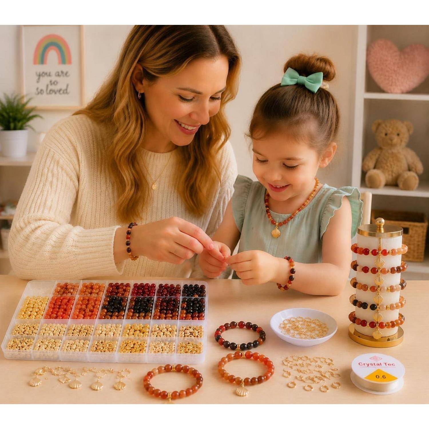 Mutter und kleines Mädchen basteln Perlenbänder an einem Basteltisch mit Perlenablegen, fertigen Armbändern und einem Schmuckausstellungsständer.