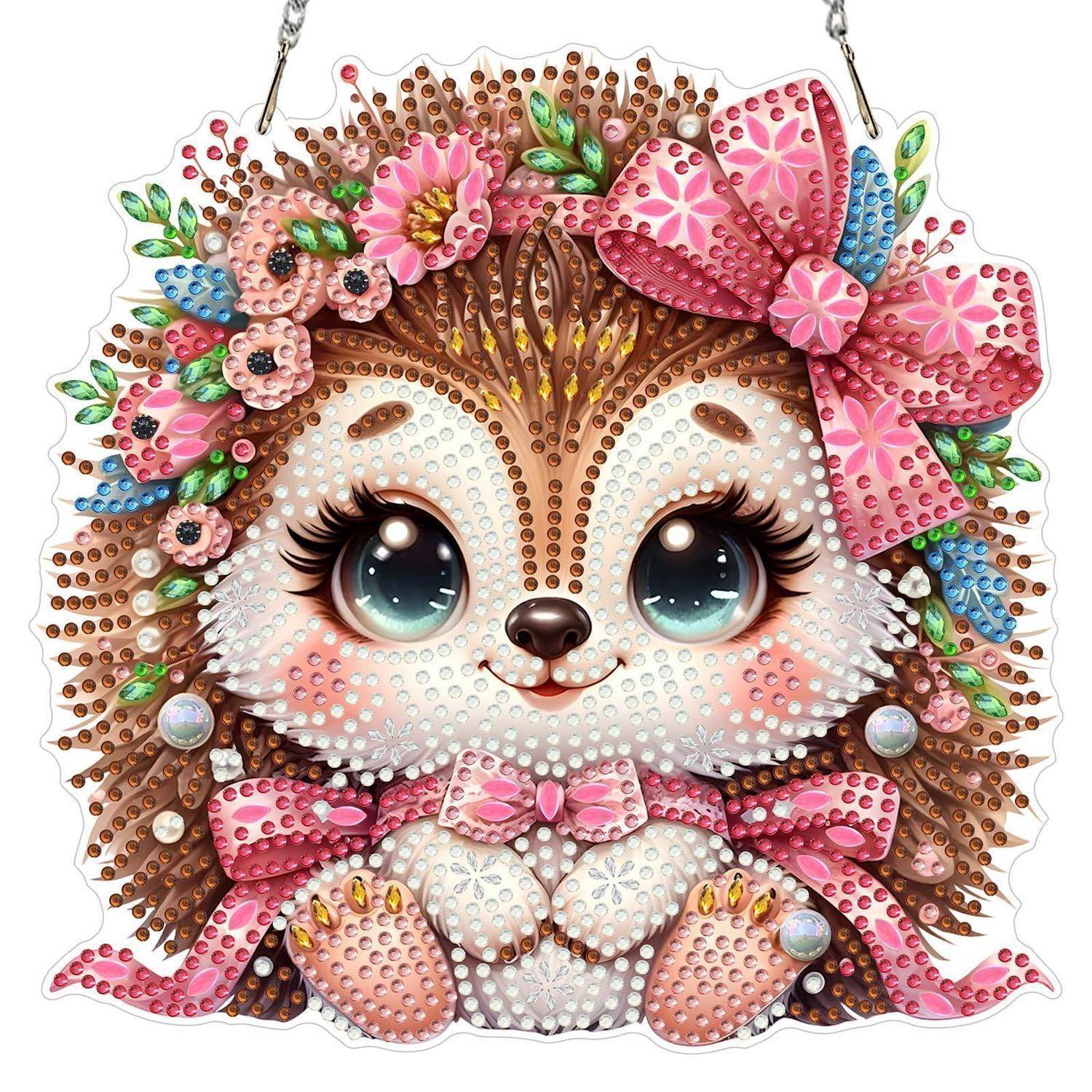 Niedliches verziertes Igel-Ornament mit großen Augen, rosa Blumen und einer Schleife, das an einer Kette hängt.