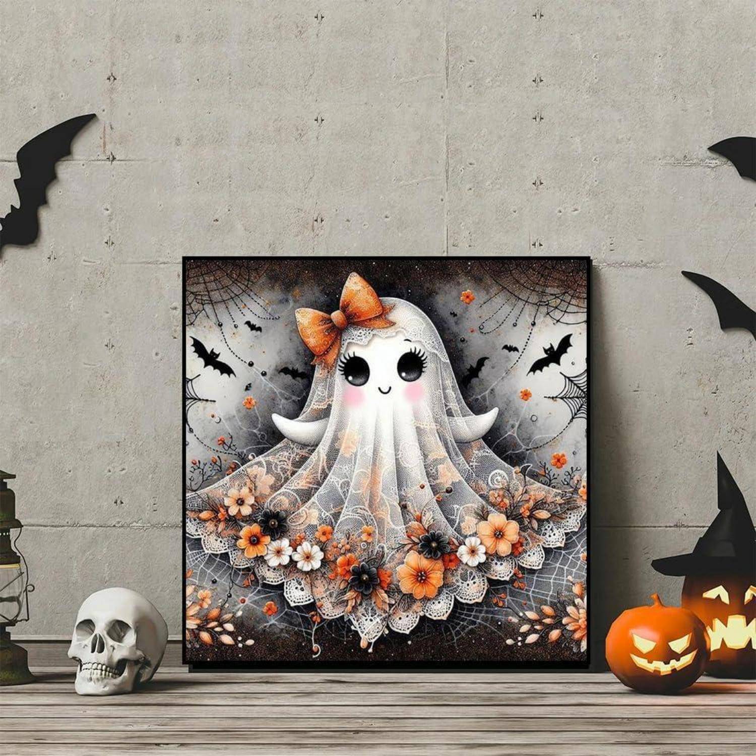 Illustrierung eines zu Halloween gerahmten Geistes mit einer Schleife, Spitzenschleier, orangefarbenen Blumen und Fledermäusen, an einer Wand mit Kürbis- und Totenkopfdekorationen angebracht.